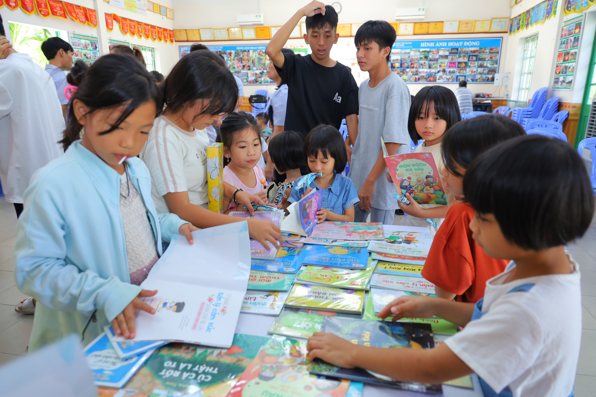 Các em nhỏ trong Làng trẻ em SOS Nha Trang đọc sách được trưng bày tại buổi phục vụ sách lưu động.