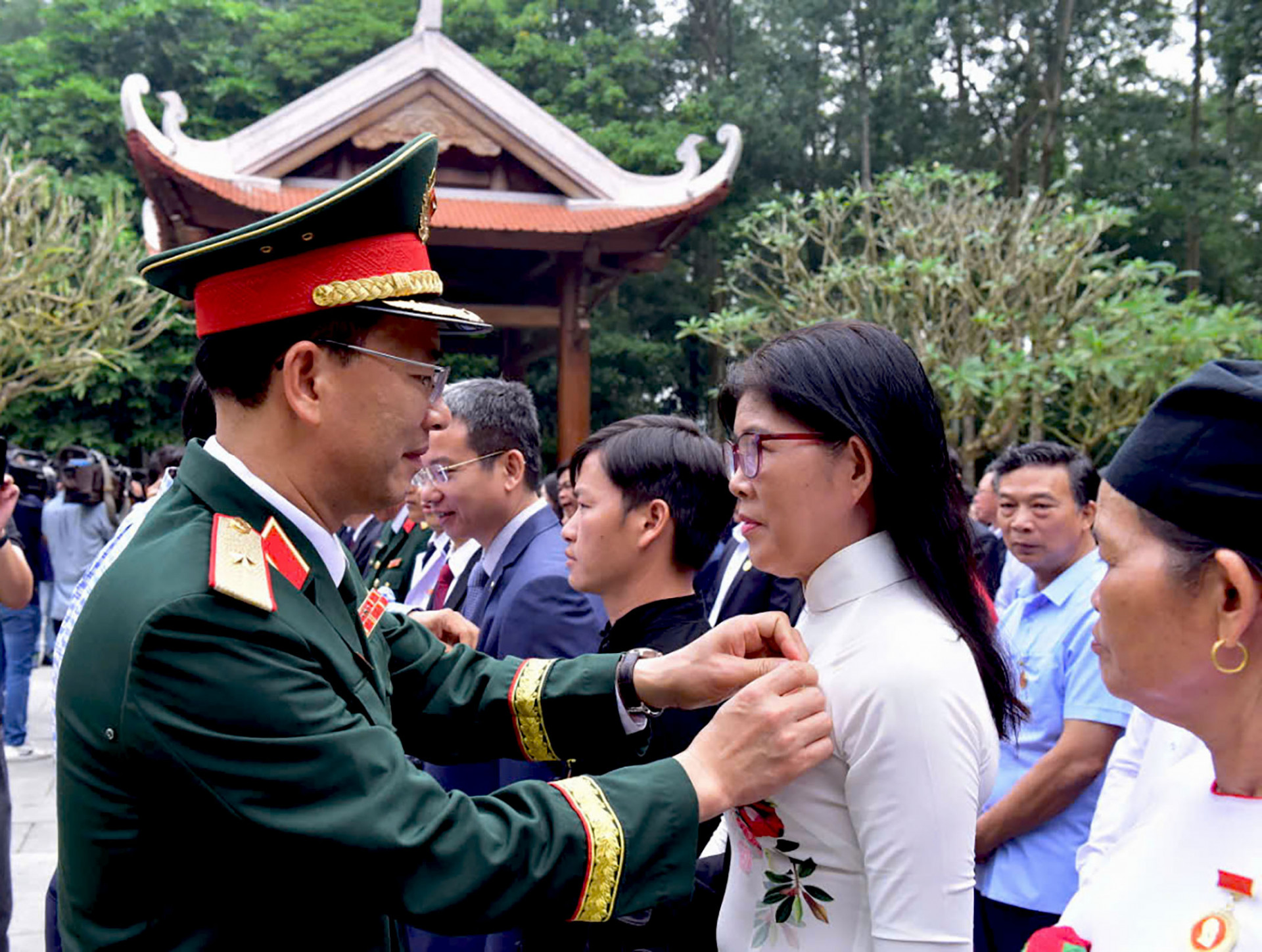 Đại diện Bộ Tư lệnh Bảo vệ Lăng Chủ tịch Hồ Chí Minh gắn Huy hiệu Bác Hồ cho cô Đức dự lễ báo công dâng Bác tại Khu di tích K9 (TP. Hà Nội). (Ảnh nhân vật cung cấp).