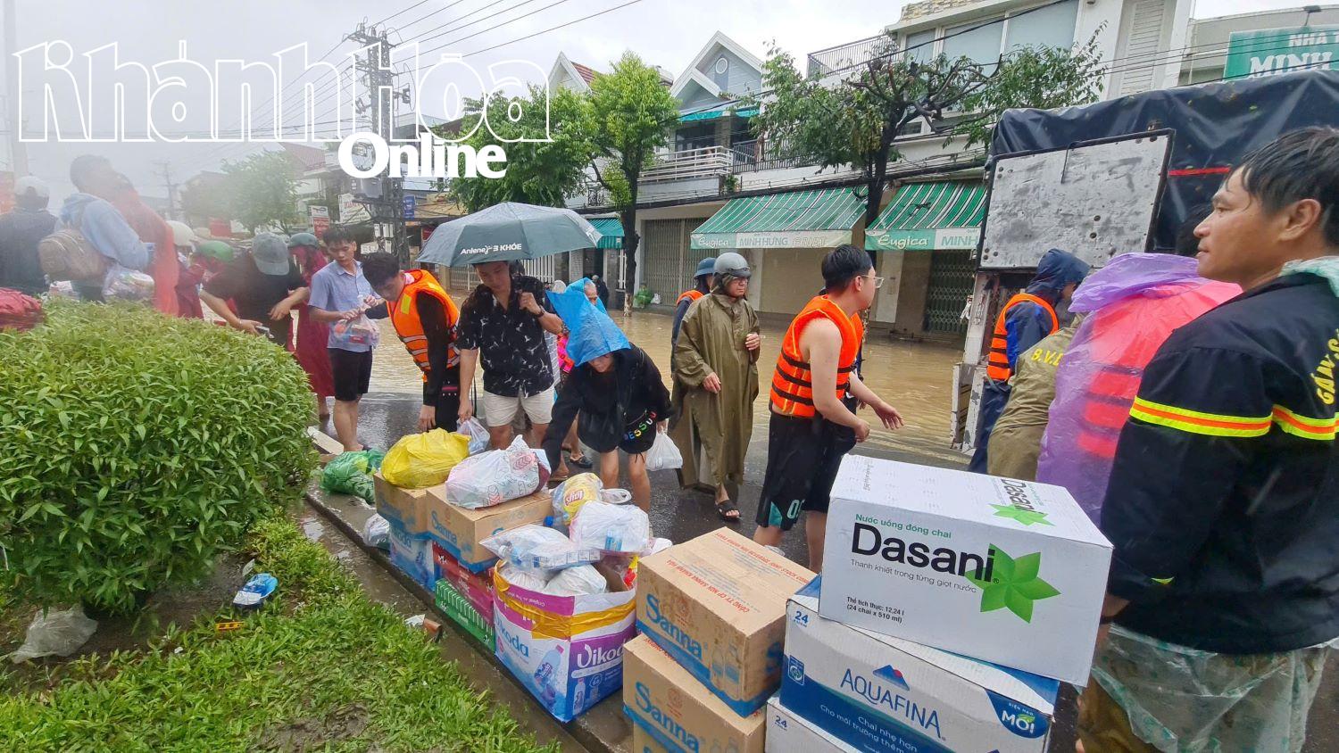 Người dân nhận đồ ăn, nước uống tại một điểm cứu trợ của nhóm thiện nguyện.
