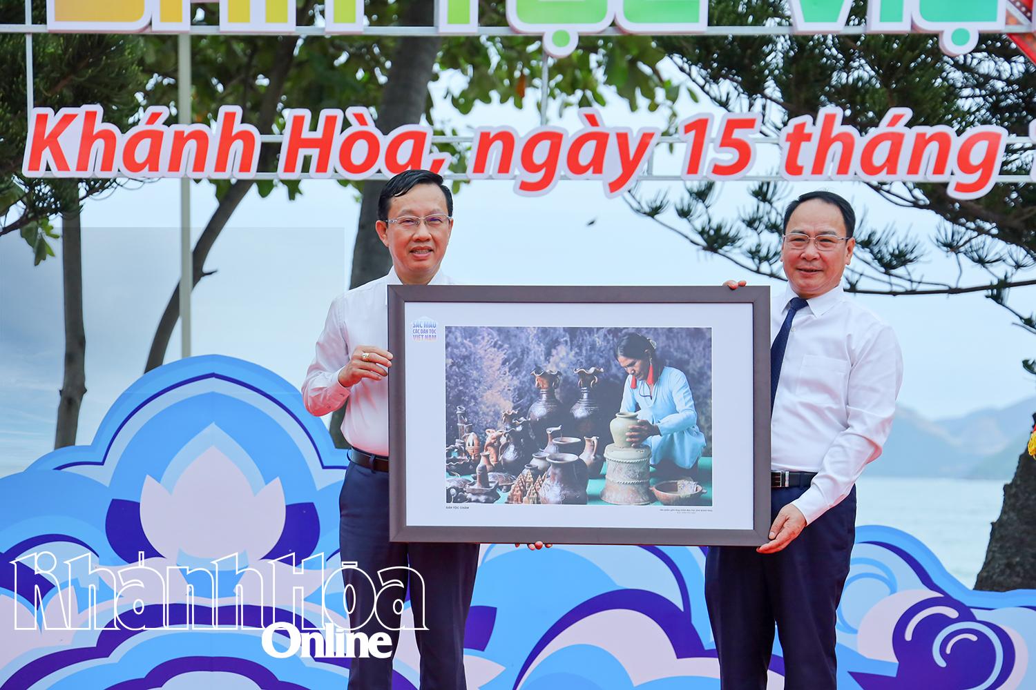 Leader of the Department of Fine Arts, Photography and Exhibition presenting the photos to the representative of Khanh Hoa Province

