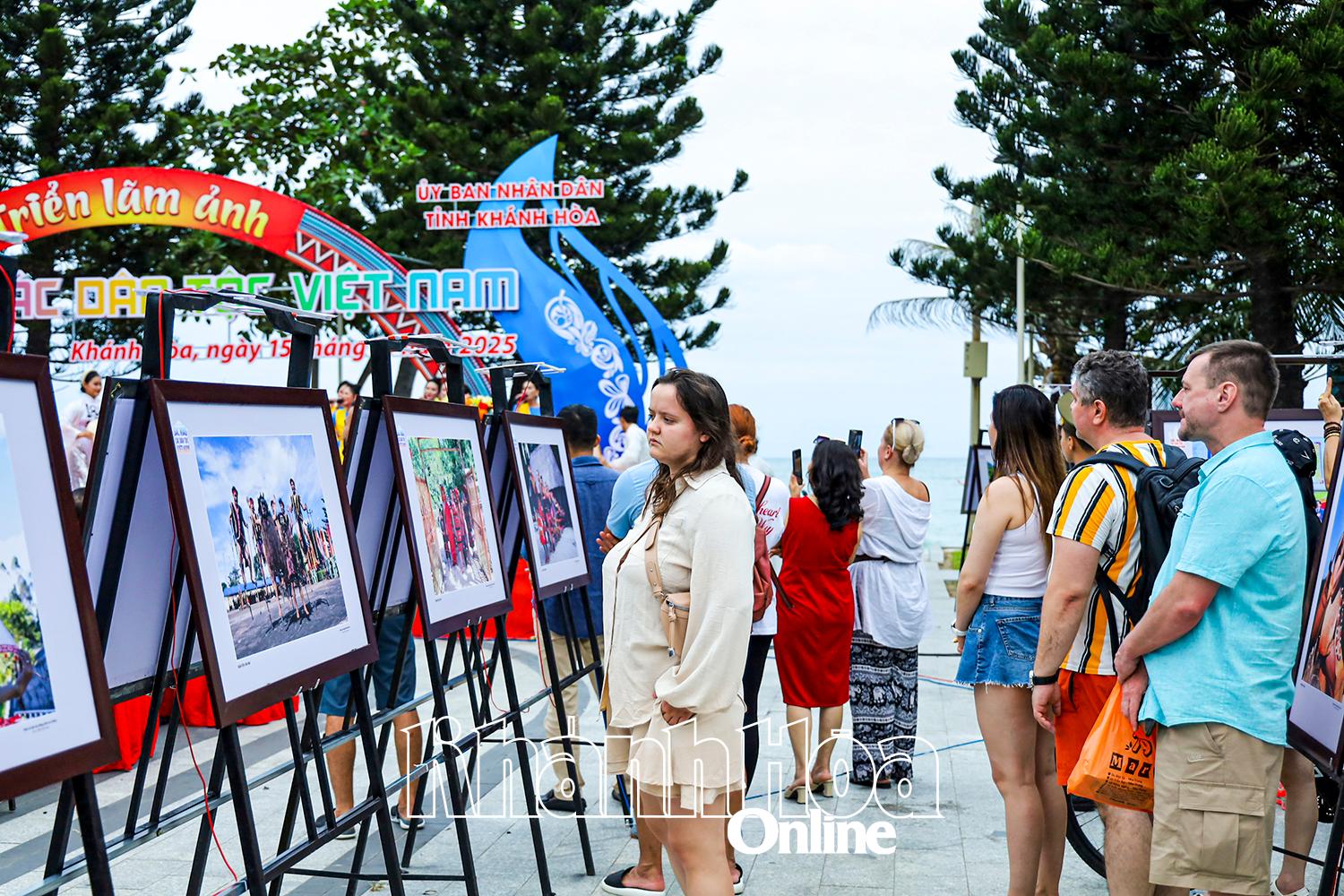 Foreign tourists viewing the exhibited photos

