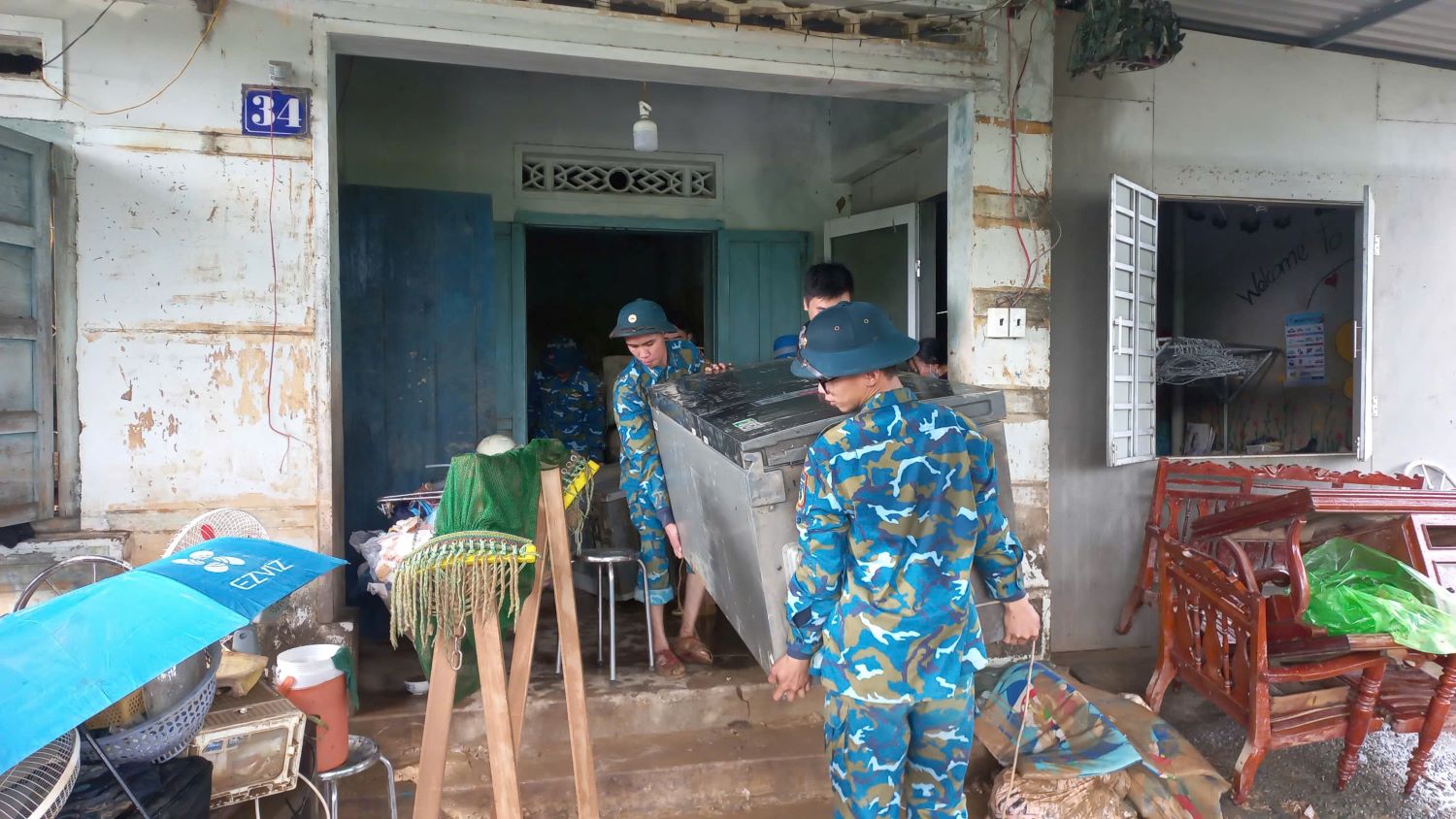 Cán bộ, chiến sĩ trung đoàn giúp dân dọn dẹp sau lũ tại xã Diên Thọ.