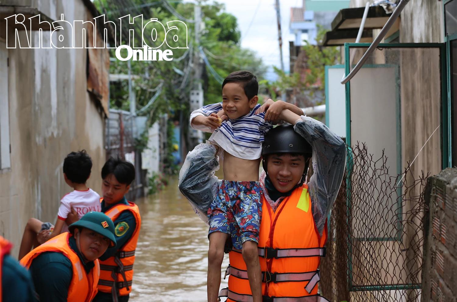 Niềm vui của cháu nhỏ và lực lượng chức năng phường Bảo An khi ra khỏi vùng ngập sâu.
