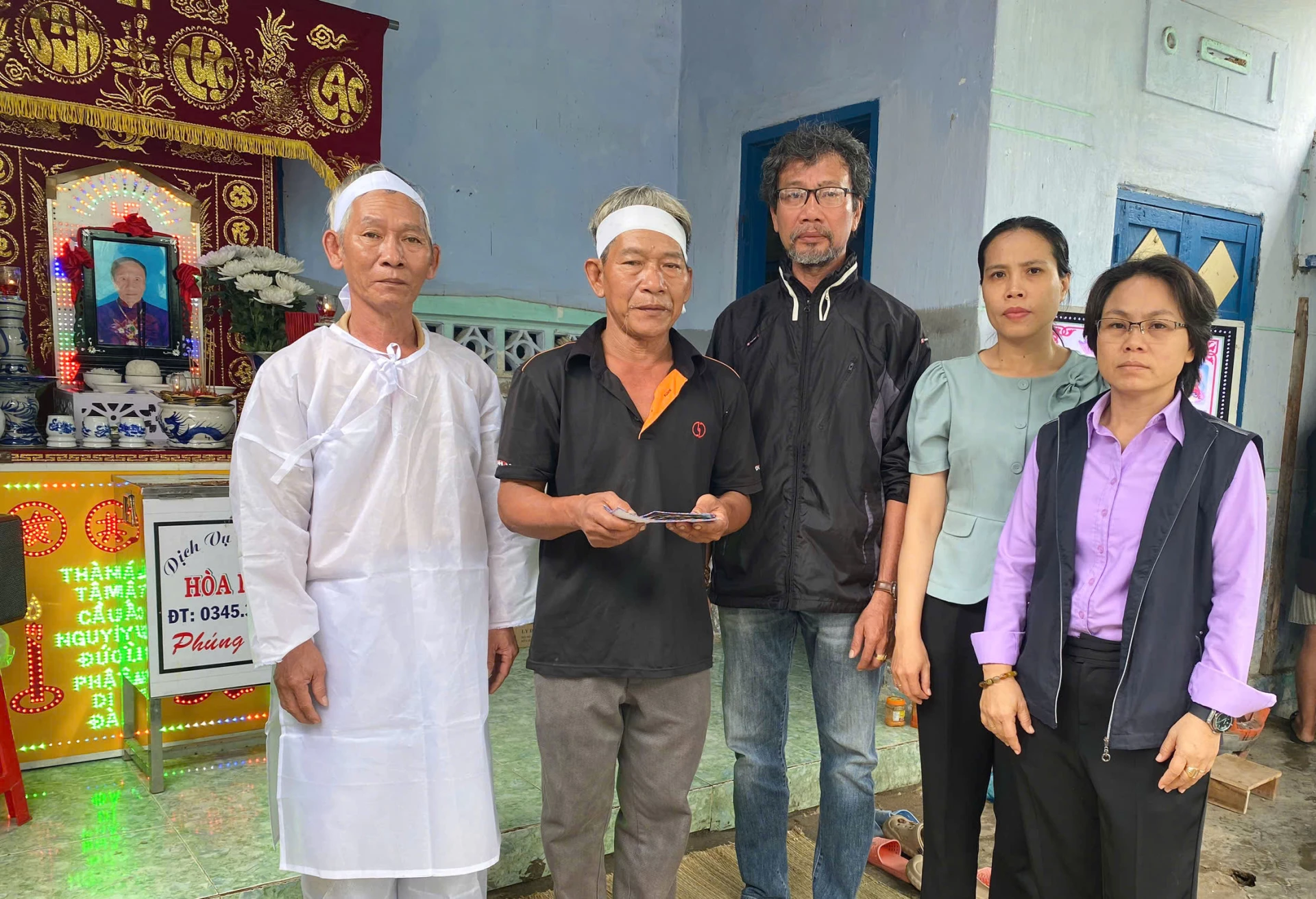 Trao tiền hỗ trợ mai táng cho người nhà của bà Hoa.