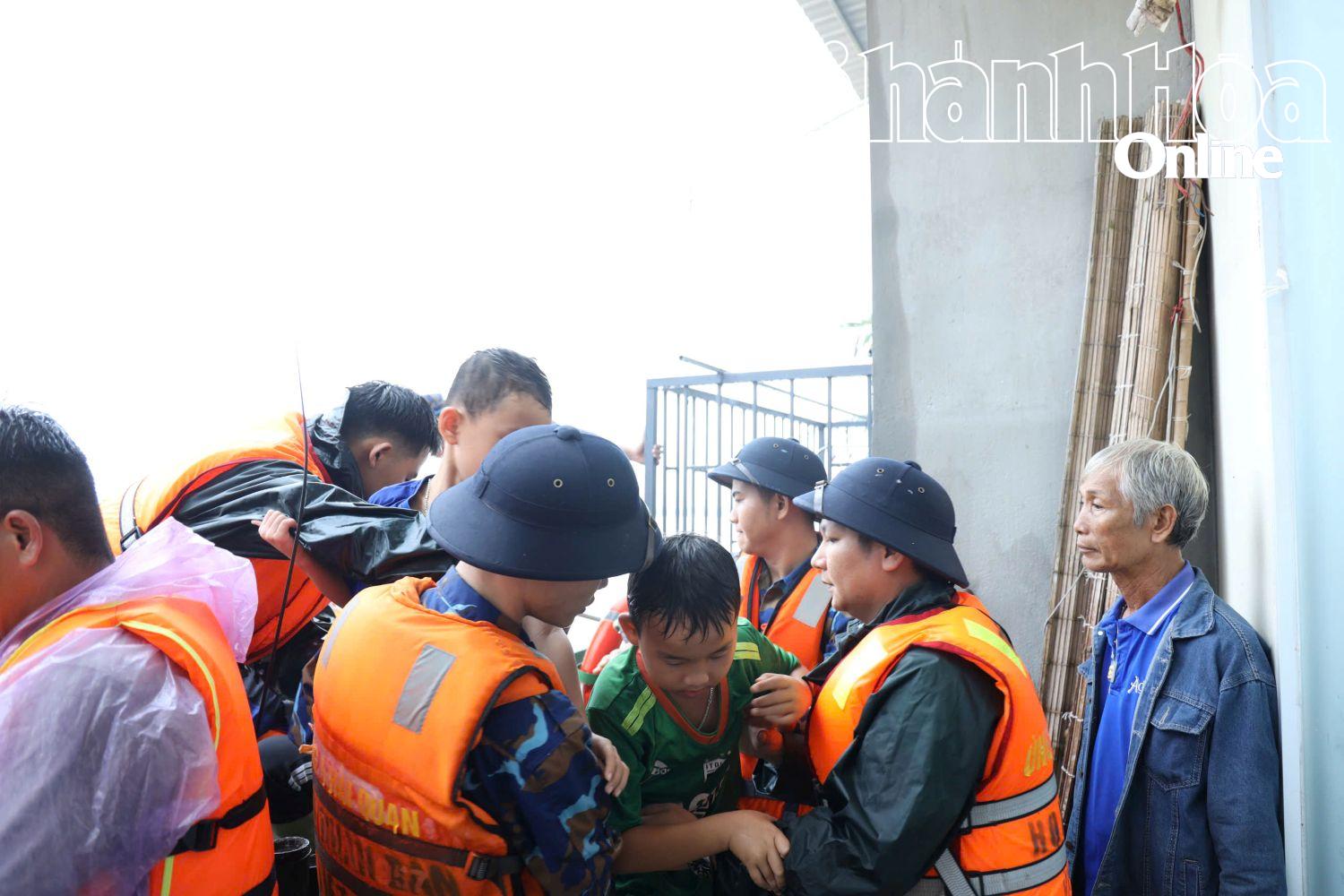 Lực lượng cứu hộ đưa một cháu bé từ xuồng tới nơi sơ tán an toàn.