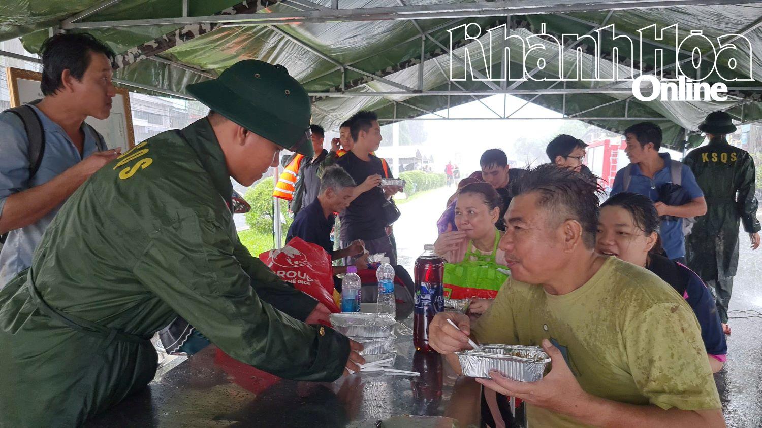 Ông Nguyễn Văn Trung cùng vợ và con được tiếp thêm sức lực từ những hộp cháo nóng.