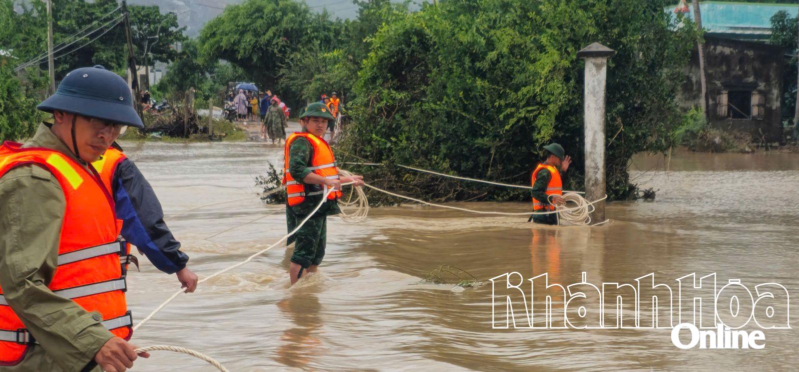 Để tiếp cận khu dân cư bị chia cắt, các cán bộ chiến sĩ phải căng dây, thận trọng băng qua