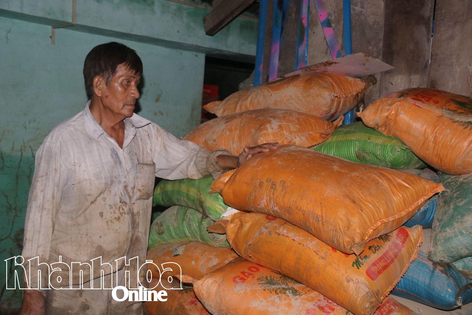 Chủ tiệm tạp hóa thất thần trước những bao gạo bị ngâm trong dòng nước lũ nhiều ngày, đang bốc mùi ẩm mốc