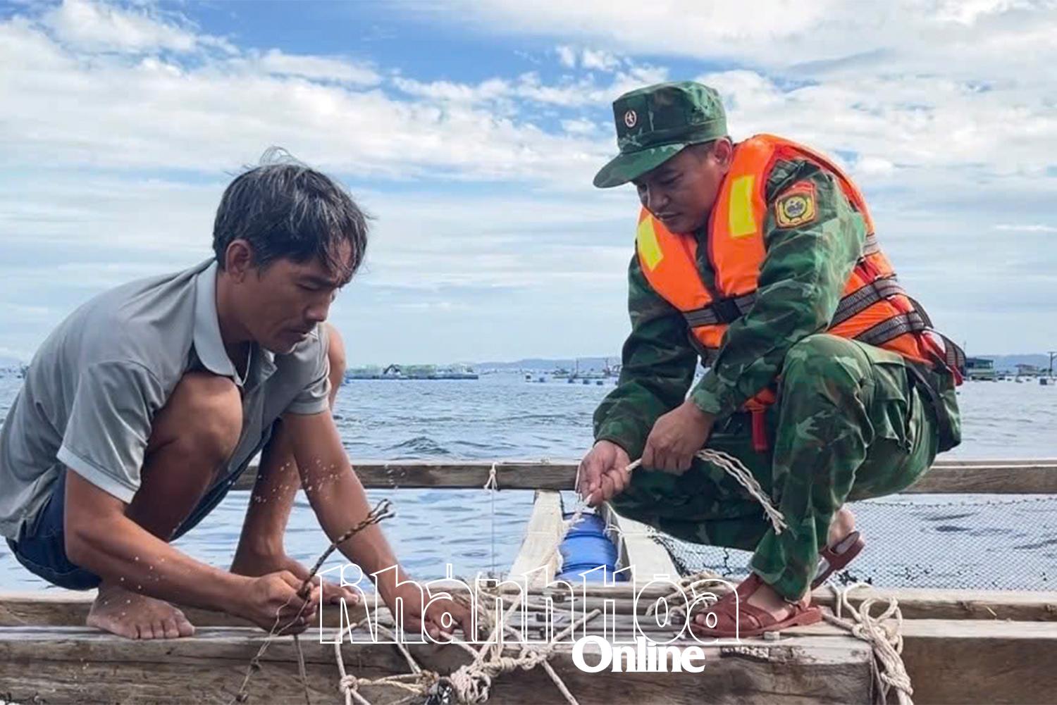 Bộ đội Biên phòng giúp ngư dân gia cố lồng bè trên vùng biển phường Bắc Cam Ranh. Ảnh: VĂN KỲ
