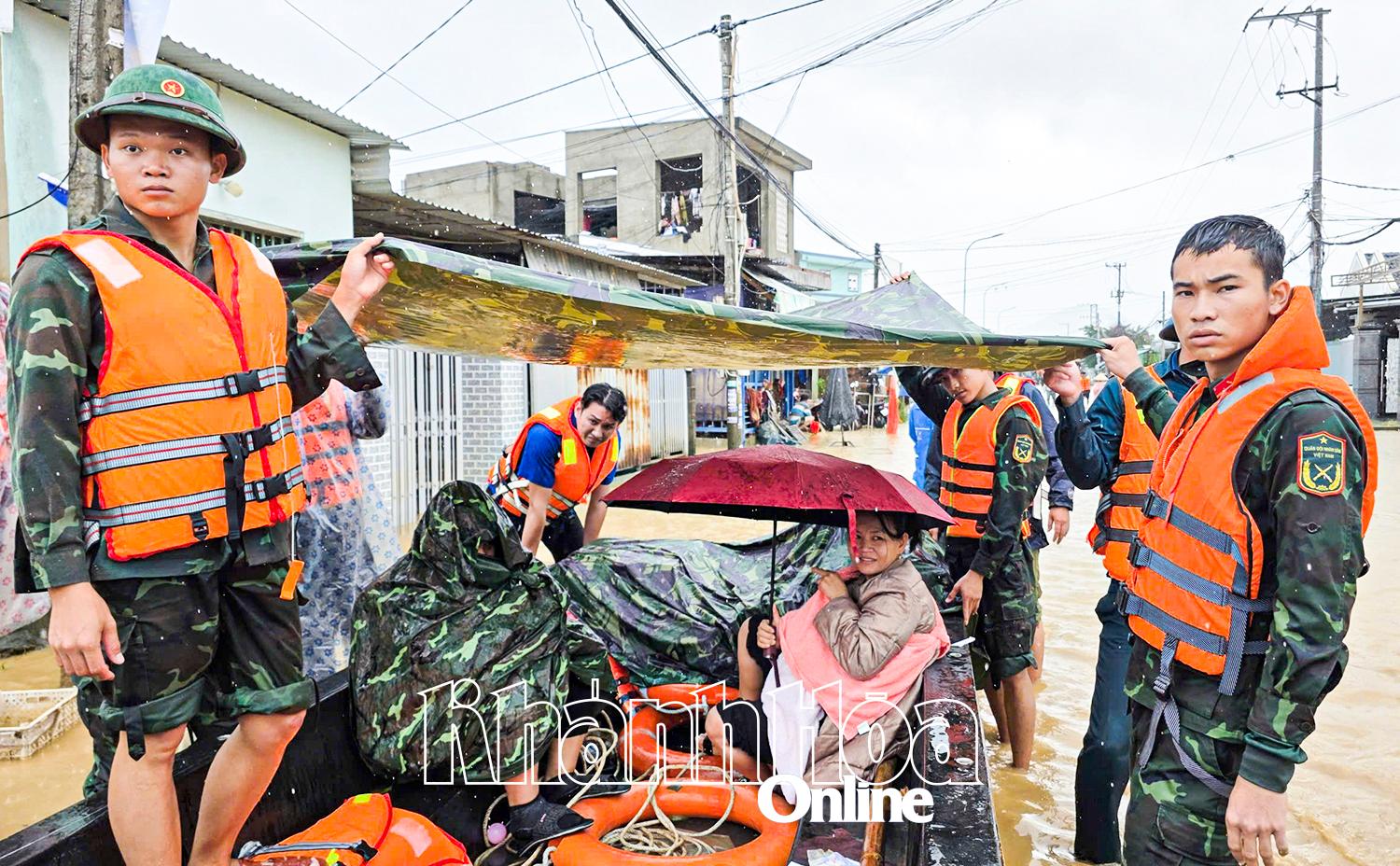 Cán bộ, chiến sĩ che mưa cho người mẹ mới sinh con 9 ngày tuổi.
