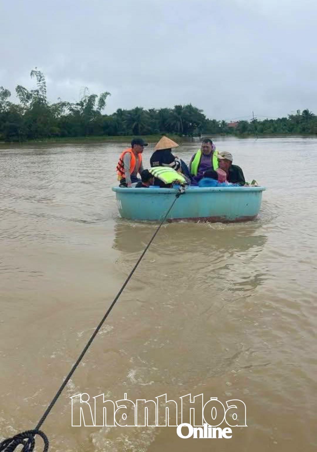 Người dân được đội thuyền thúng tiếp cận đưa ra khỏi vùng ngập sâu.