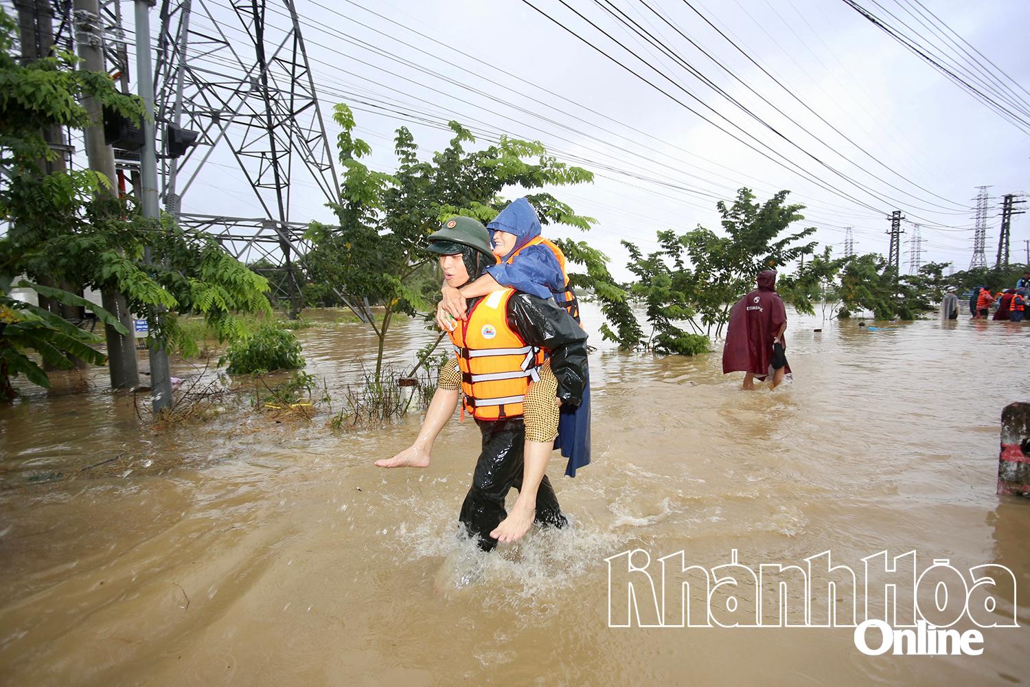 Một cụ bà được lực lượng cứu hộ cõng ra ngoài.