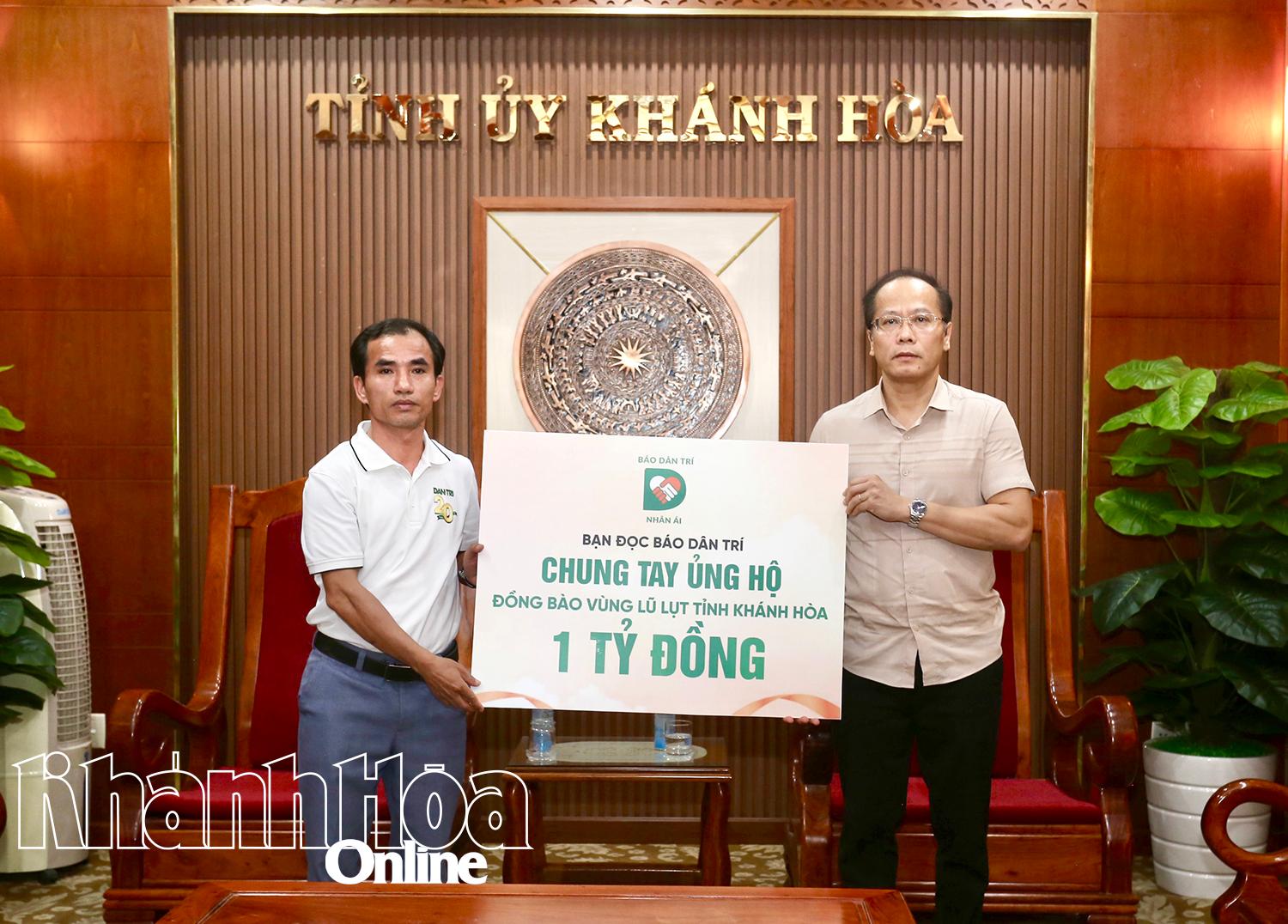 Đồng chí Nguyễn Khắc Hà-Phó Bí thư Tỉnh ủy, Chủ tịch Ủy ban MTTQ Việt Nam tỉnh (bên phải) tiếp nhận 1 tỷ hỗ trợ của đại diện báo Dân Trí.