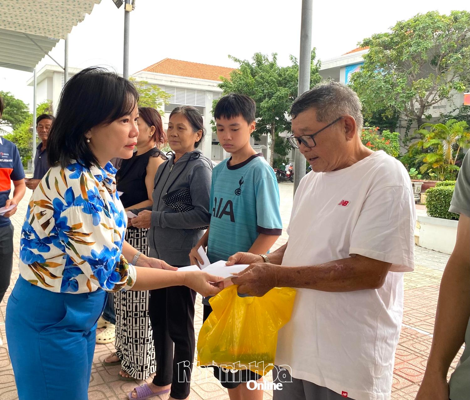 Bà Thái Thị Lệ Hằng - Giám đốc Báo và Phát thanh, Truyền hình Khánh Hòa trao quà cho người dân thôn Thủy Tú.