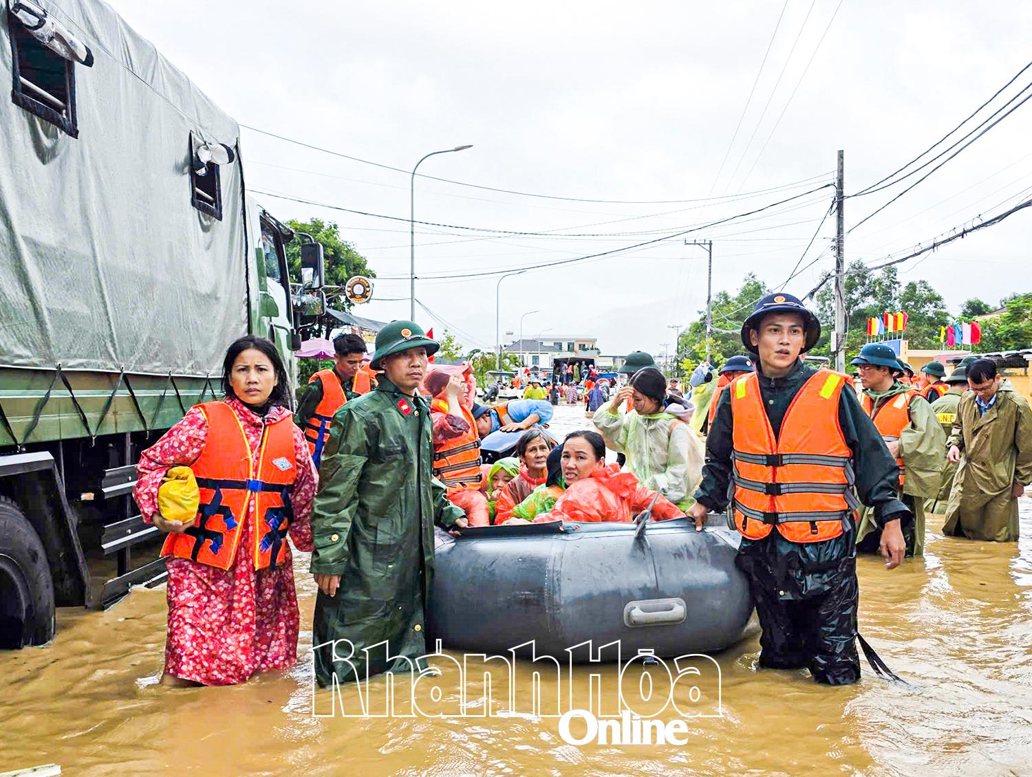 Lực lượng chức năng hỗ trợ người dân rời vùng lũ.
