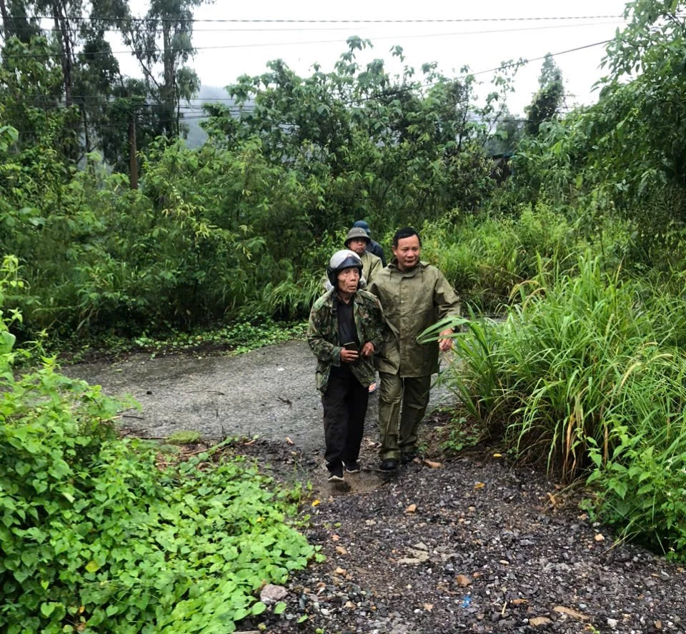 Lực lượng chức năng xã Tây Ninh Hòa hỗ trợ di dời người dân dưới chân đèo Phượng Hoàng đến nơi an toàn.