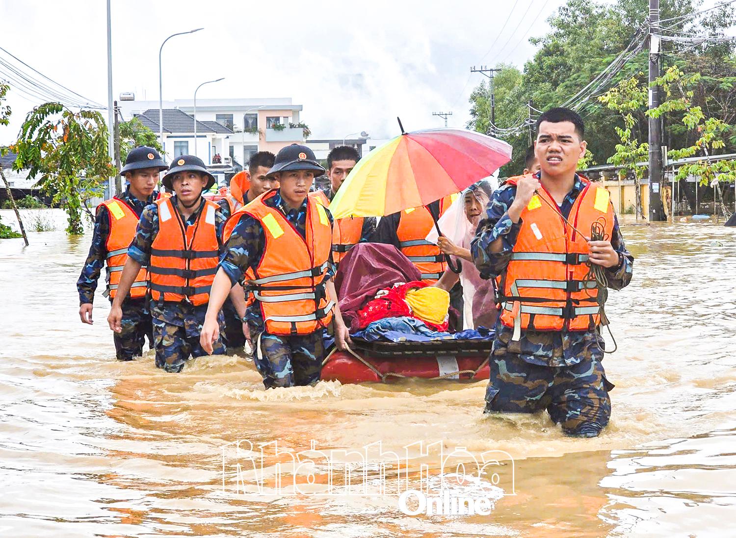 Lực lượng chức năng hỗ trợ người dân rời vùng lũ.