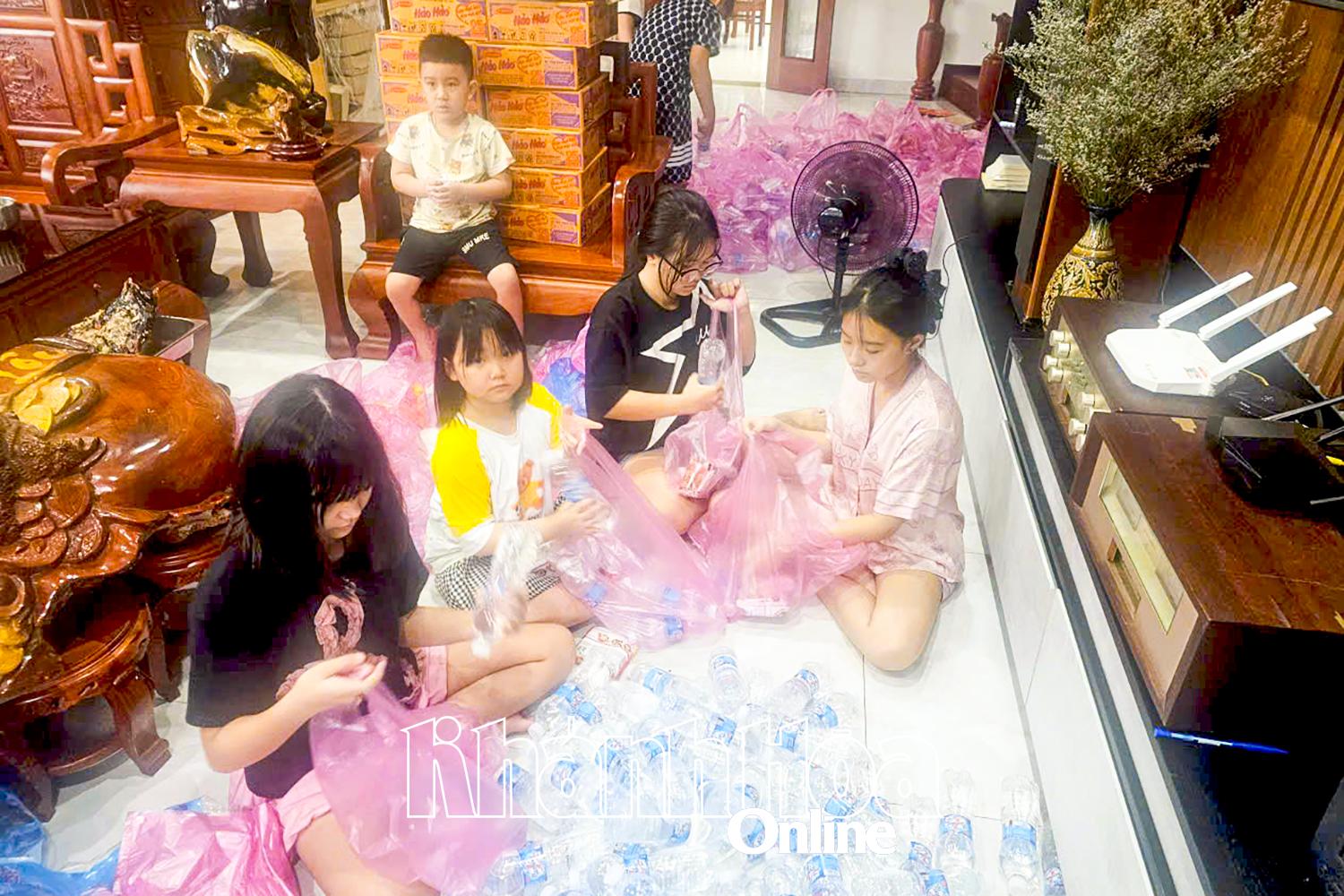 Các em nhỏ phường Nam Nha Trang tham gia đóng gói hàng hỗ trợ bà con vùng ngập lụt nặng.