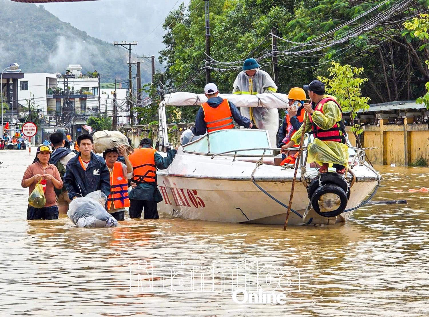 Người dân được ca nô đưa ra khỏi vùng lũ.