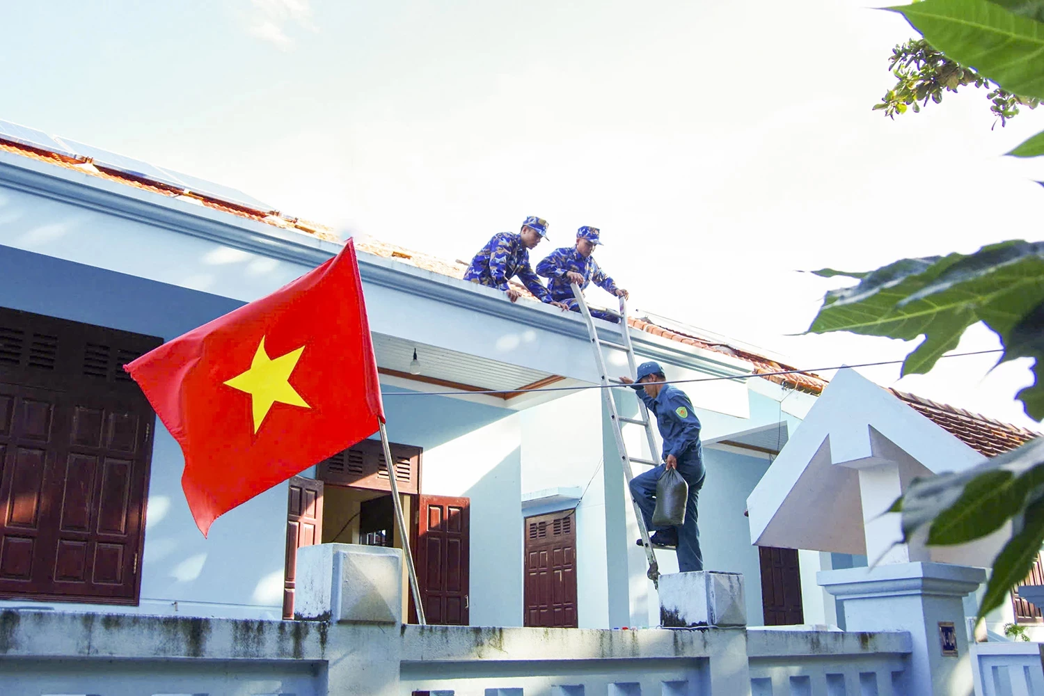 Cán bộ, chiến sĩ đảo Trường Sa hỗ trợ người dân gia cố nhà.
