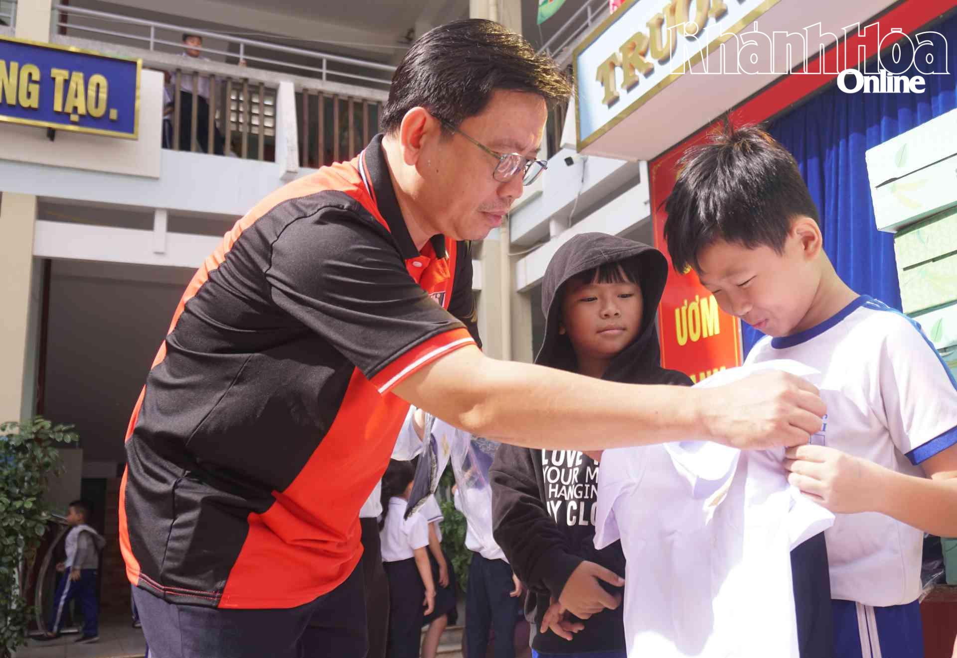 Nhà báo Cung Phú Quốc - Phó Giám đốc Báo và Phát thanh, Truyền hình Khánh Hòa trao đồng phục cho học sinh Trường Tiểu học Phương Sài.