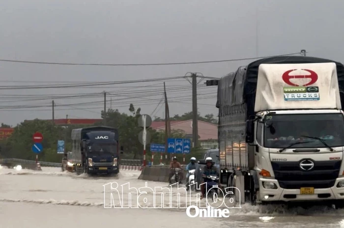 Cảnh sát giao thông xã Thuận Nam hỗ trợ người dân vượt đoạn ngập trên Quốc lộ 1