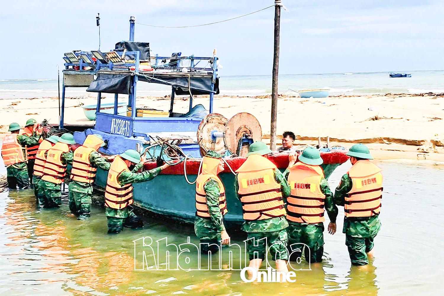 Đồn Biên phòng Phước Dinh hỗ trợ
 bà con ngư dân đưa tàu thuyền 
vào nơi trú ẩn an toàn. Ảnh: THANH XUÂN
