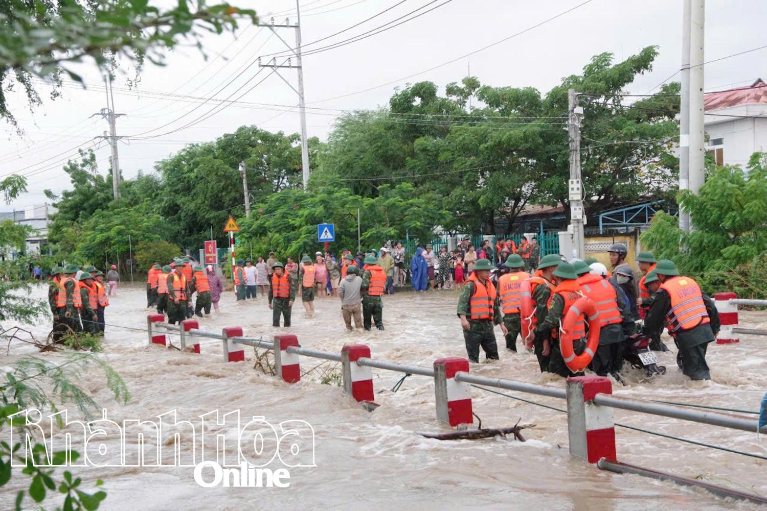 Các chiến sĩ Lữ đoàn 5 hỗ trợ người dân xã Ninh Hải qua đoạn ngập lụt.