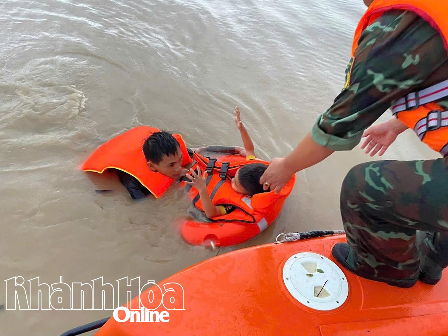 Các chiến sĩ hỗ trợ di dời trẻ em khỏi vùng nước ngập sâu ở phường Phan Rang.