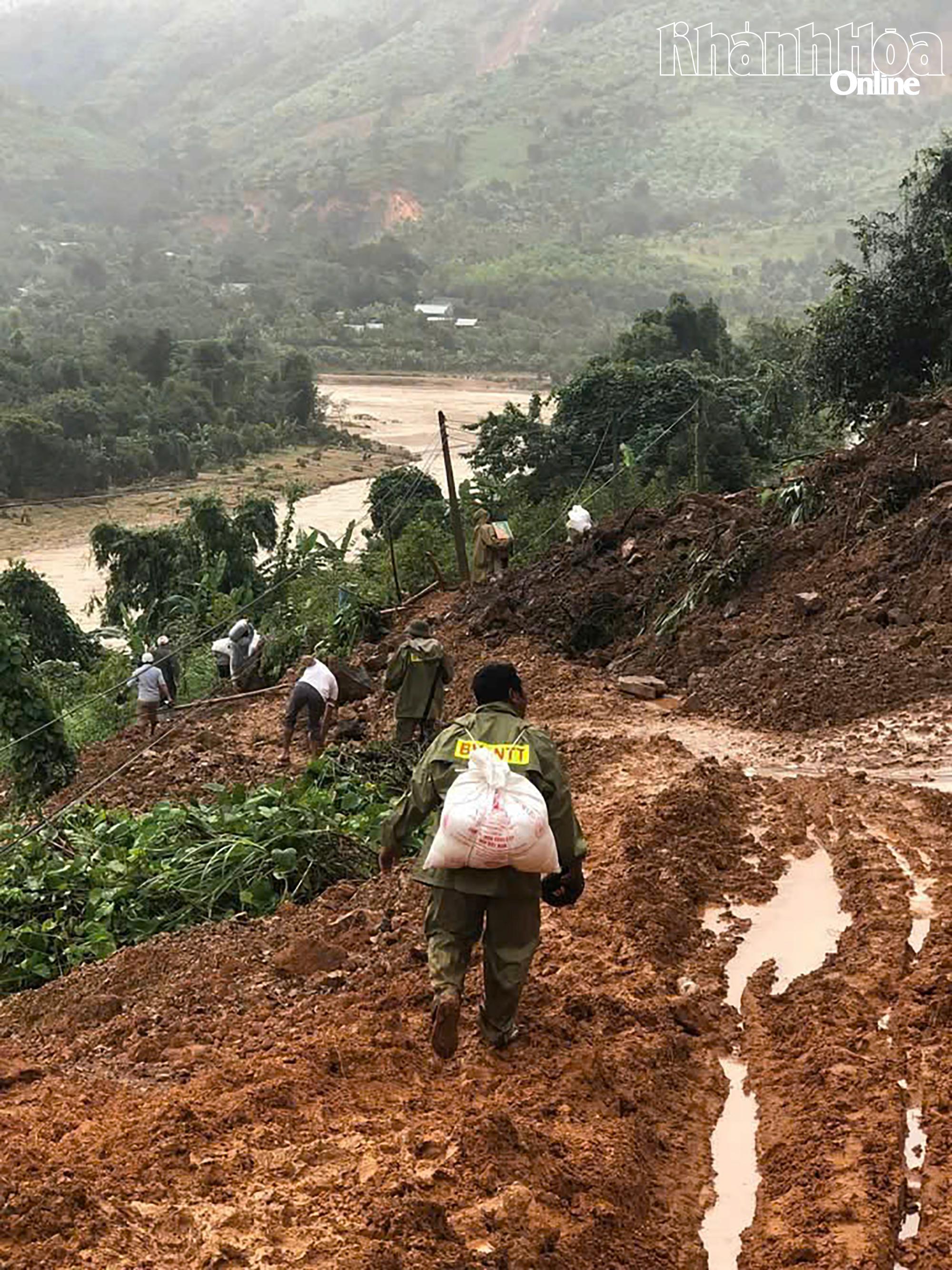 Lực lượng chức năng xã Tây Khánh Sơn gùi tiếp tế cho người dân thôn Tà Giang 2 (Ảnh địa phương cung cấp0