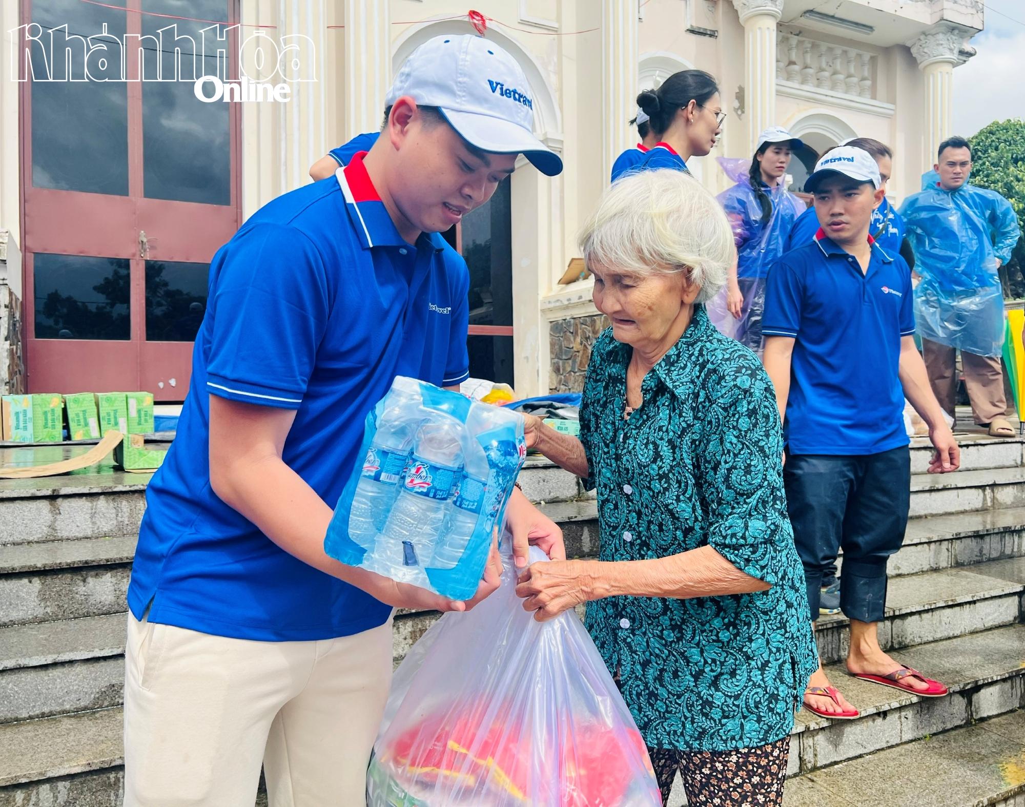 Nhân viên Vietravel trao quà cho một cụ già ở thôn Tây 3 xã Diên Điền