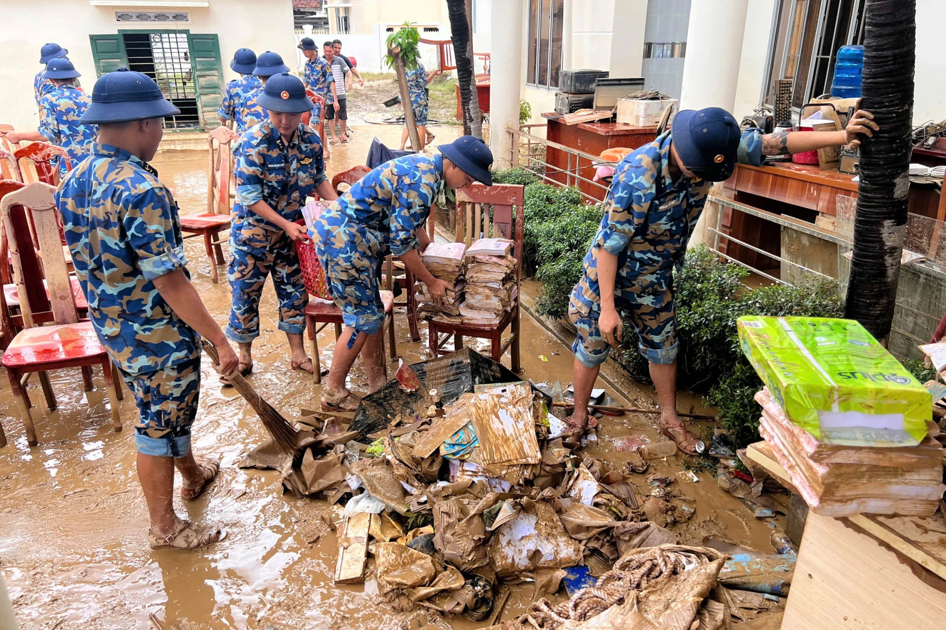 Cán bộ, chiến sĩ Vùng 4 Hải quân giúp nhân dân xã Diên Điền dọn dẹp sau lũ.
