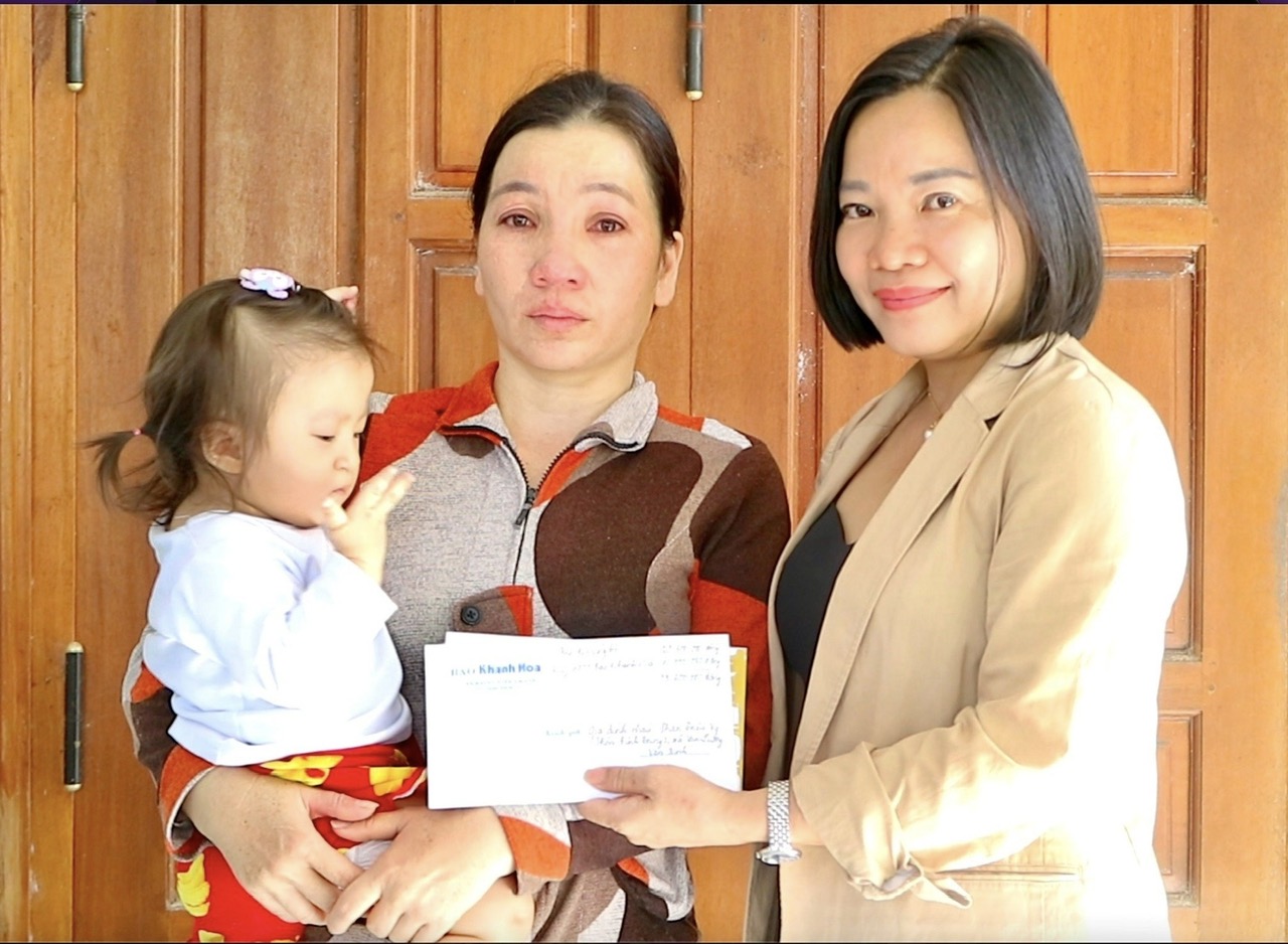 Bà Thái Thị Lệ Hằng - Tổng Biên tập Báo Khánh Hòa trao tiền ủng hộ của bạn đọc cho gia đình bé Phan Triệu Vy
