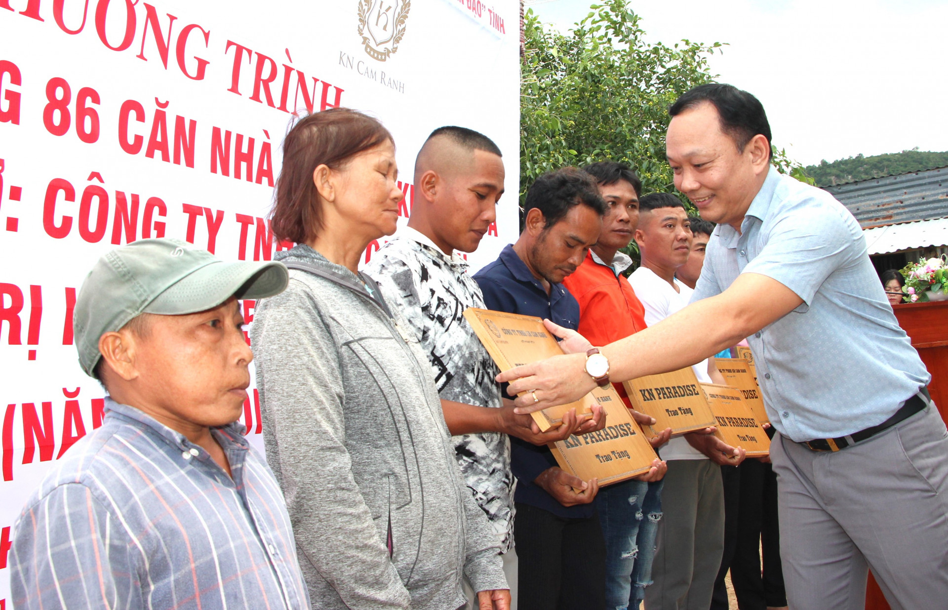 Lãnh đạo Công ty TNHH NK Cam Ranh trao bảng bàn giao nhà ở cho các hộ dân.