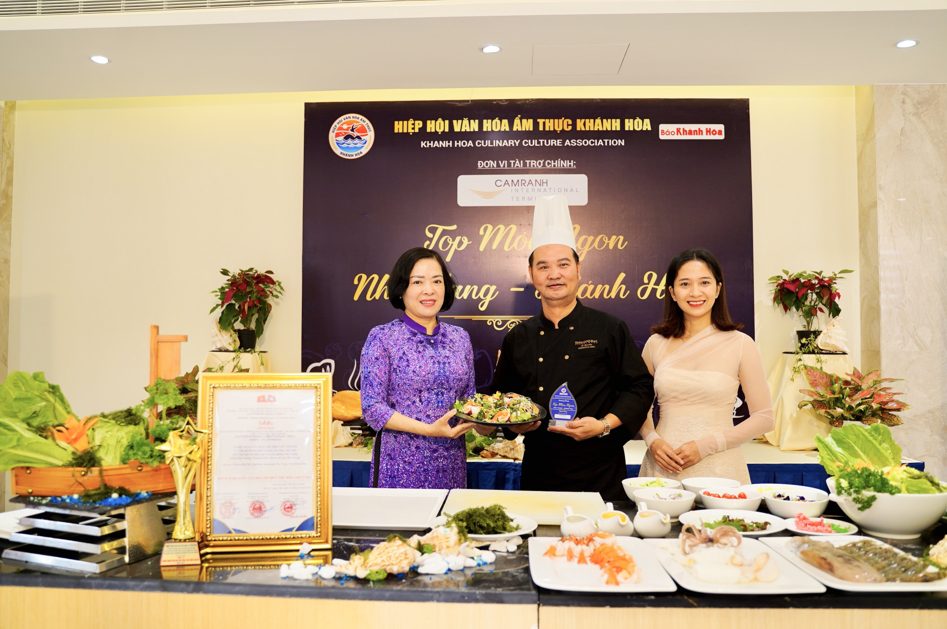 Bà Lê Thị Hồng Minh - Chủ tịch Hiệp hội Văn hóa ẩm thực Khánh Hòa (bên trái) trao kỷ niệm chương cho nghệ nhân Lê Văn Hải - DT Group & Nhà Hàng Hải Châu