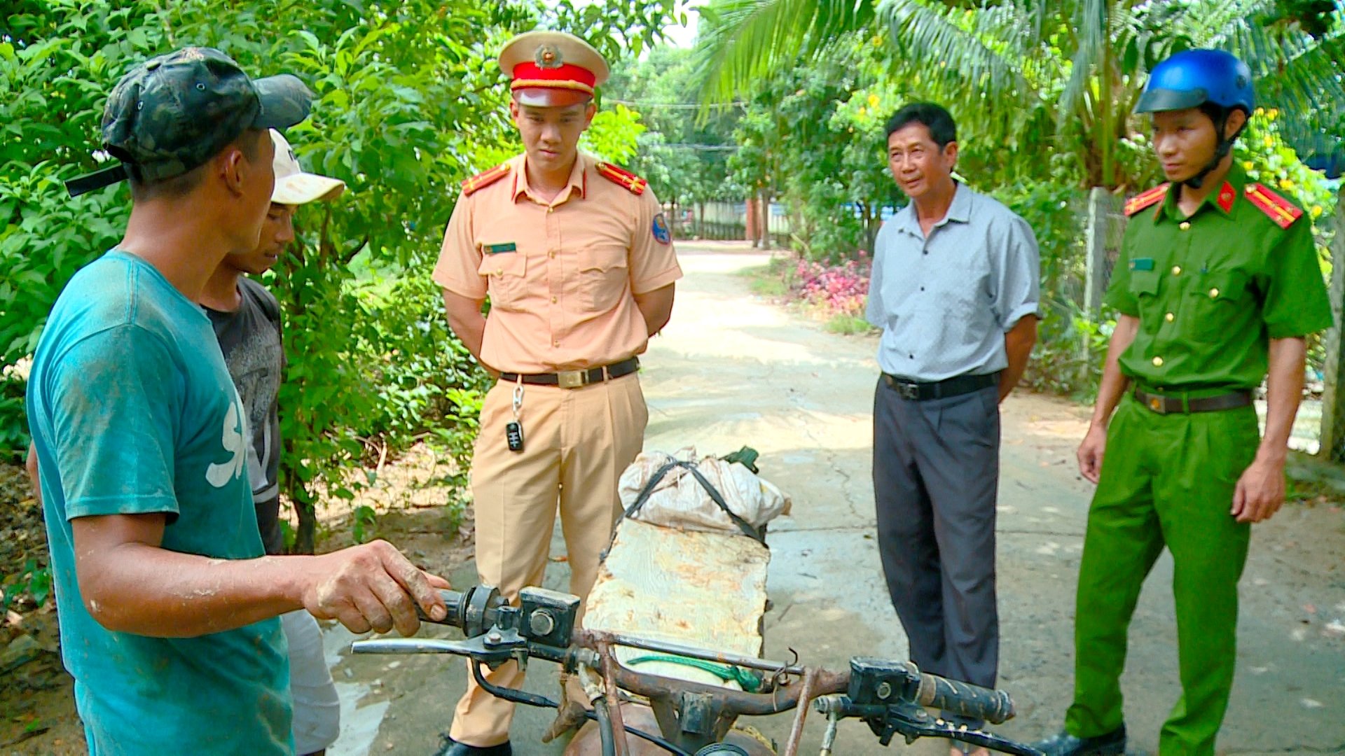 Già làng Đinh Diên (thứ 2 từ phải sang) cùng với lực lượng công an cơ sở tuyên truyền pháp luật về giao thông cho bà con trong xã