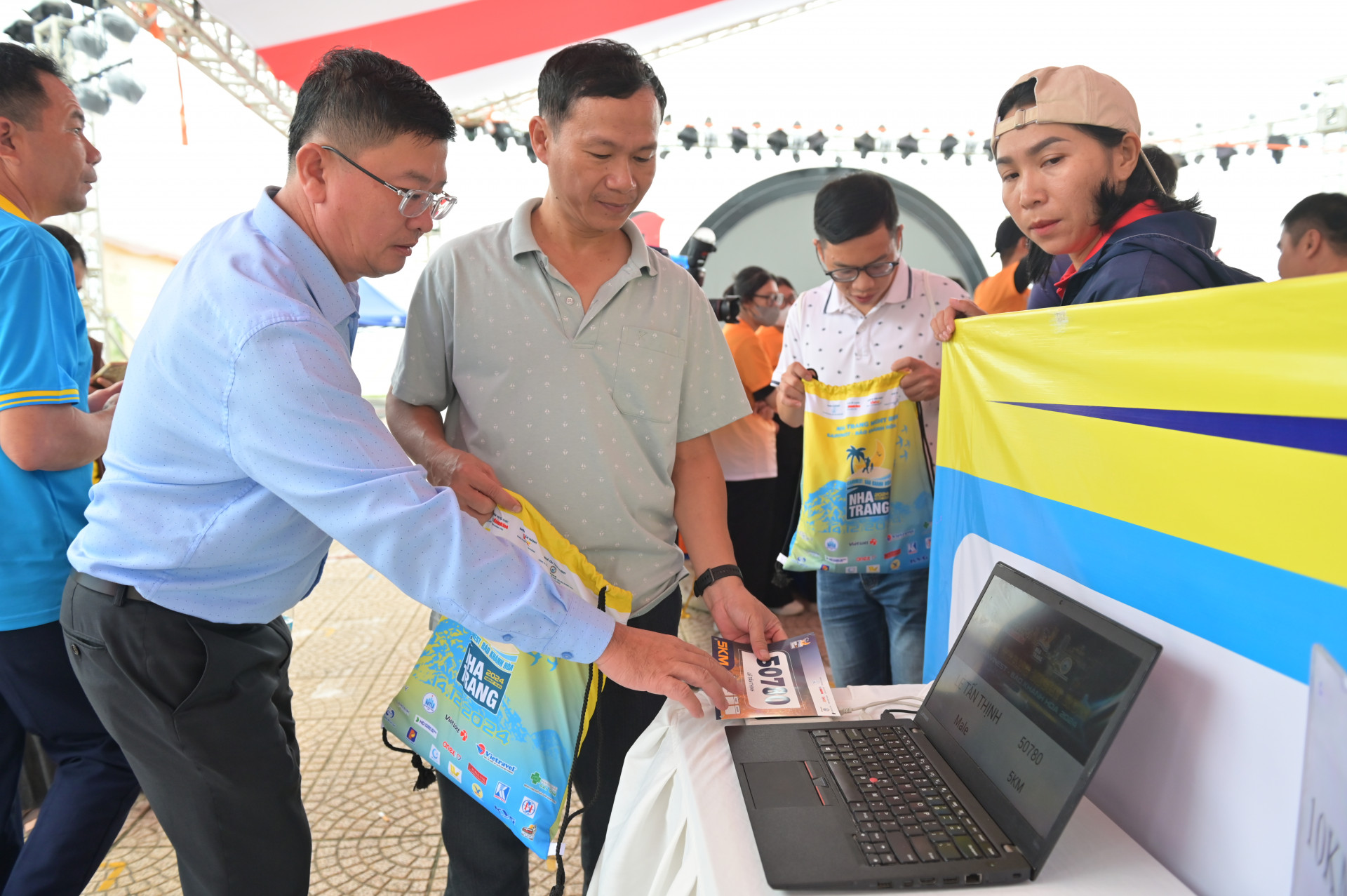 Le Hoang Trieu – Acting Deputy Editor-in-Chief of Khanh Hoa Newspaper, Head of the organizing committee, helping runners check registration information

