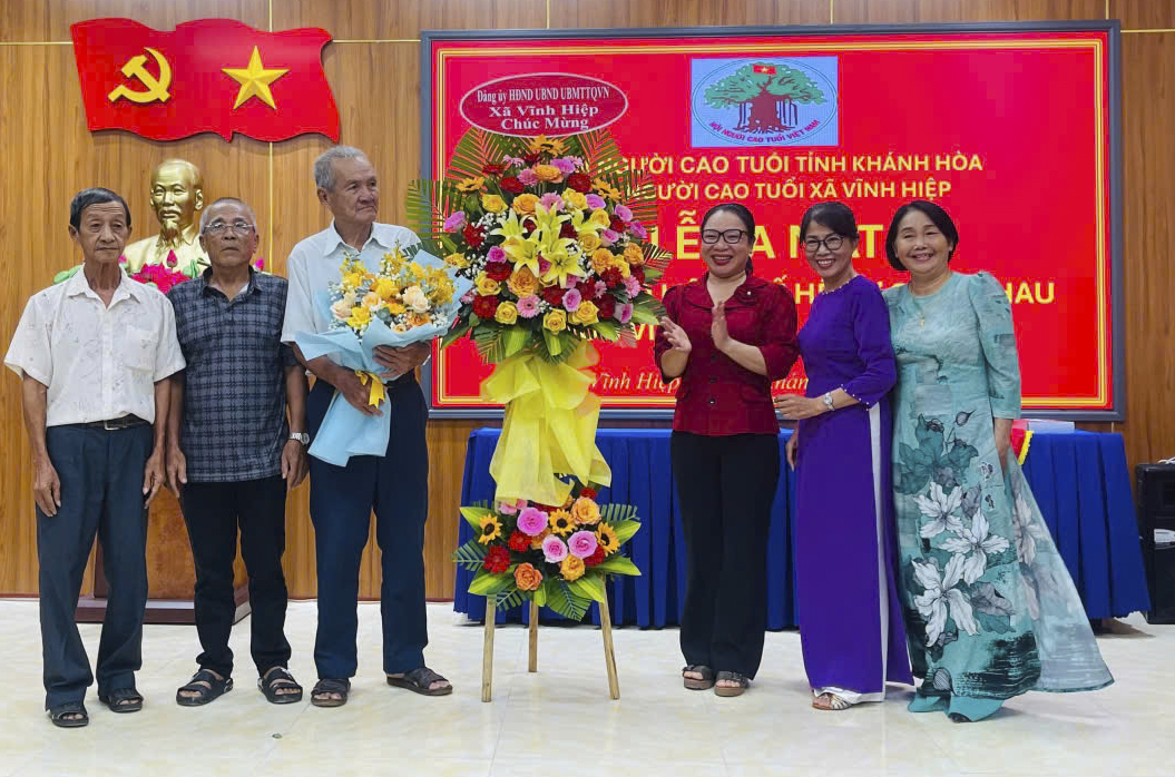 Lãnh đạo địa phương tặng hoa chúc mừng Câu lạc bộ Liên thế hệ tự giúp nhau thôn Vĩnh Châu.