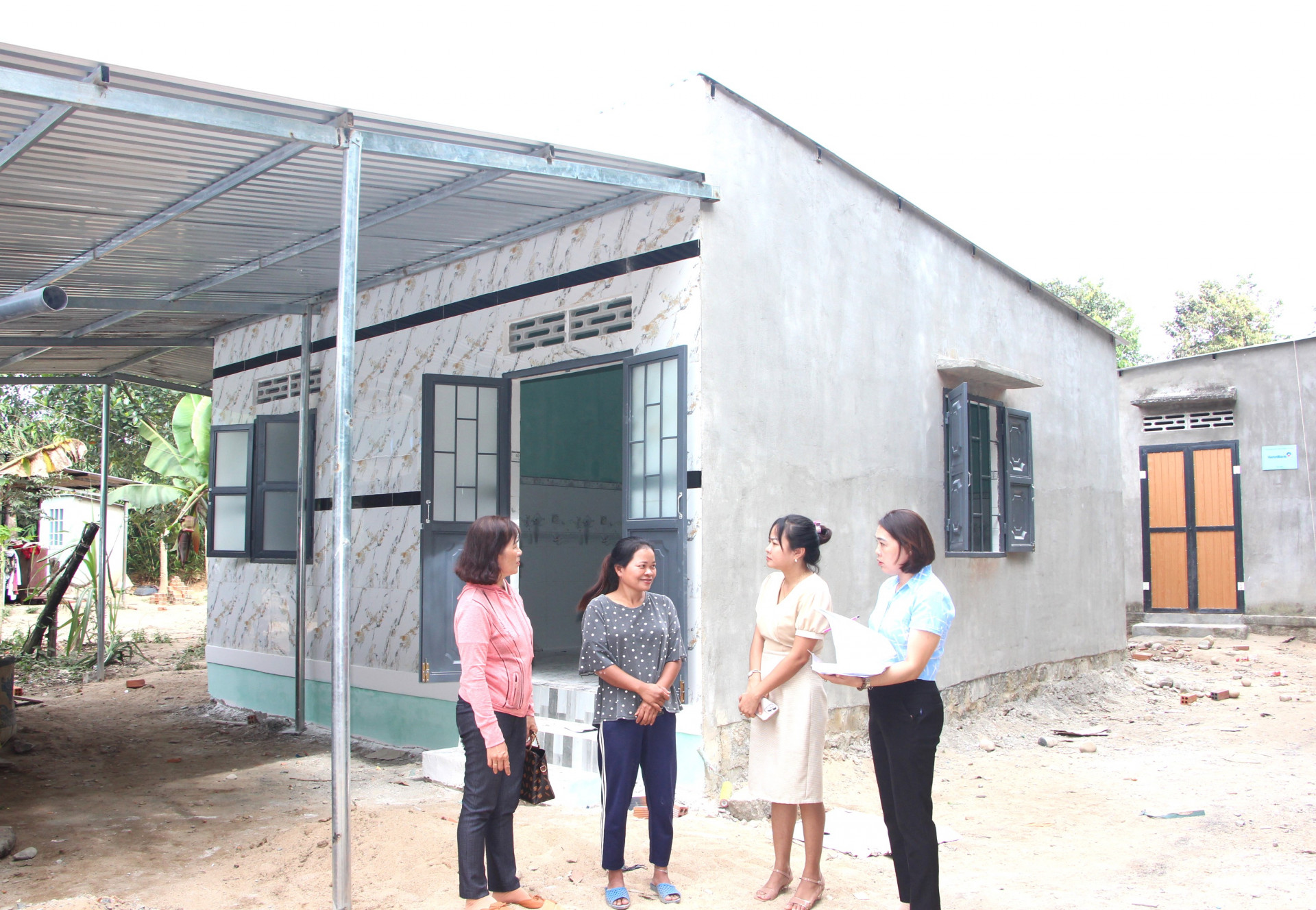 Cán bộ xã Khánh Trung (huyện Khánh Vĩnh) thăm hỏi việc hỗ trợ xây nhà ở cho hộ nghèo trên địa bàn.