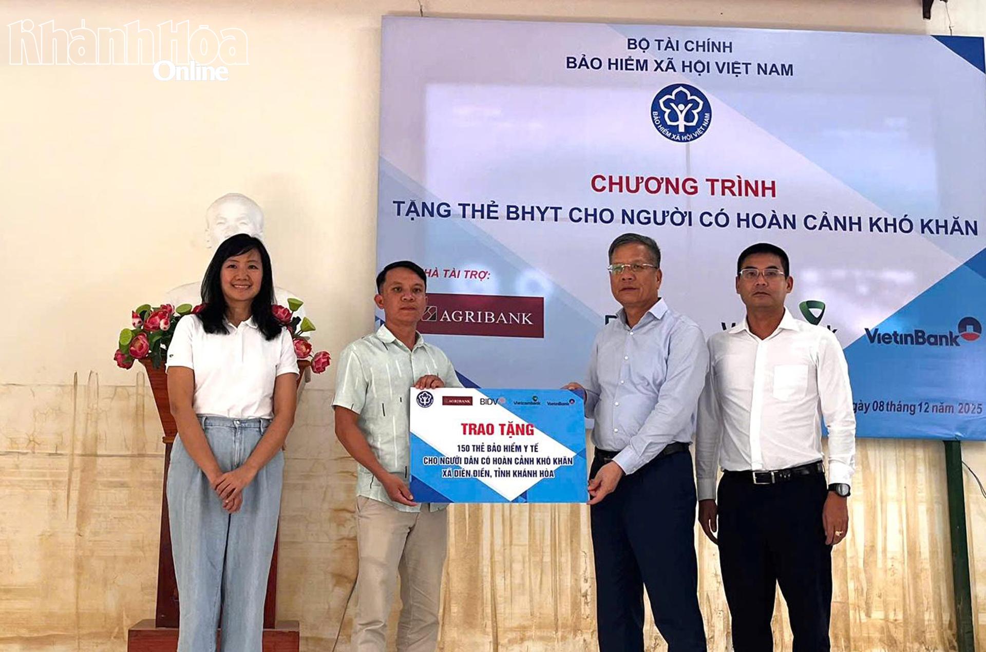 Lãnh đạo Bảo hiểm xã hội Việt Nam trao bảng tượng trưng 150 thẻ bảo hiểm y tế cho người dân xã Diên Điền.
