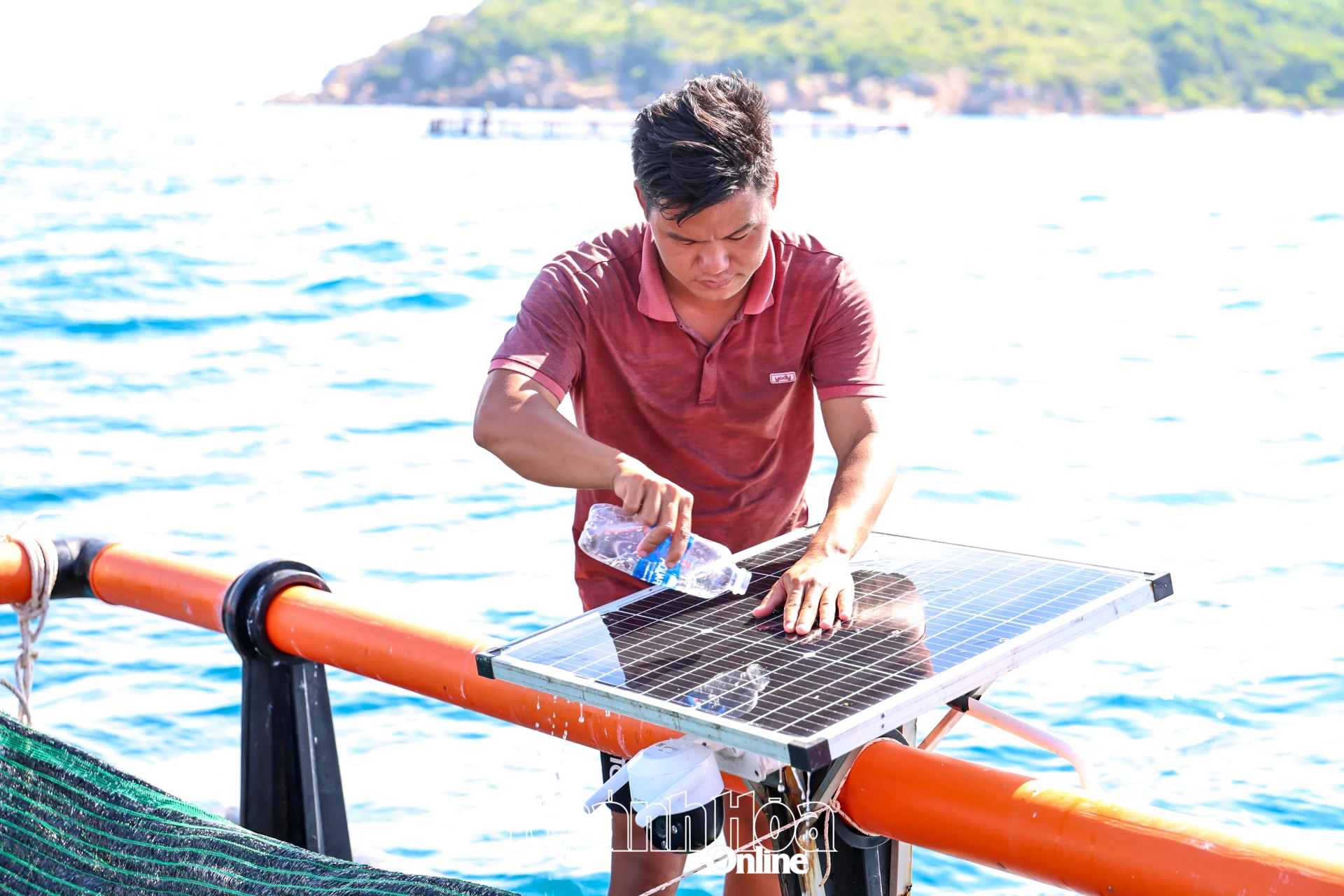 Ngư dân xã Cam Lâm vệ sinh tấm pin năng lượng mặt trời trên lồng HDPE nuôi thủy sản.