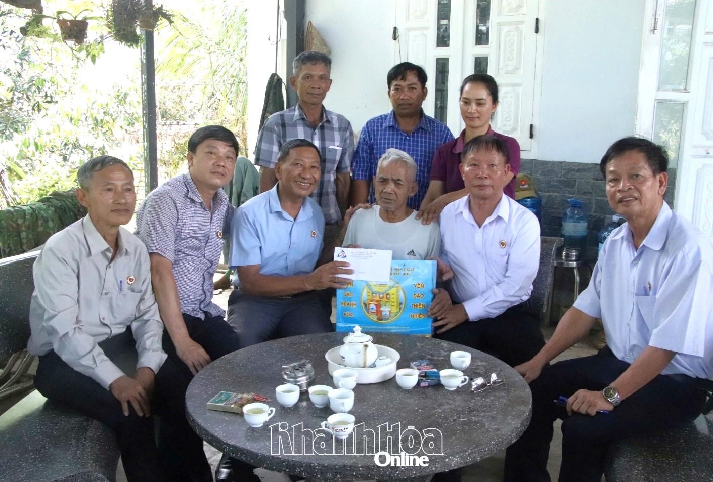Ông Nguyễn Bá Lân (thứ ba từ trái qua) tặng quà cho Anh hùng Lực lượng vũ trang nhân dân Bo Bo Tới (xã Đông Khánh Sơn).