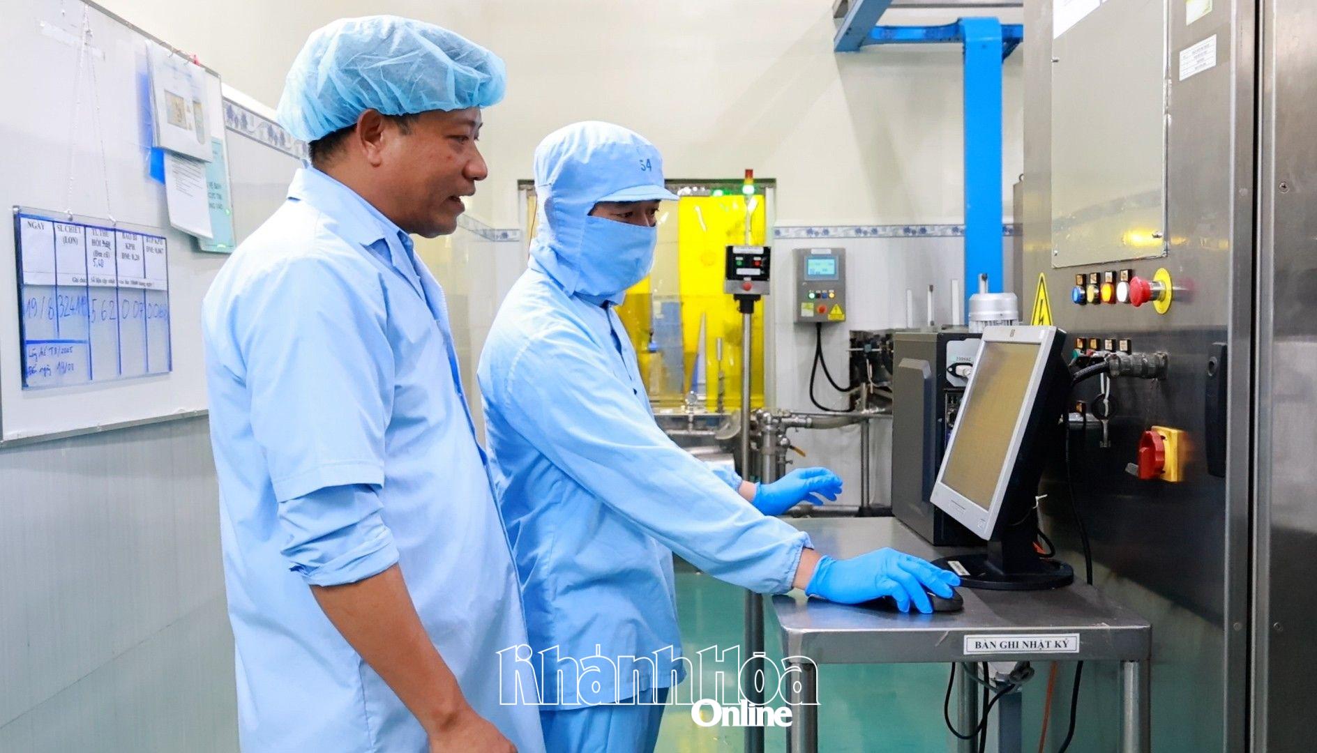 Ông Bùi Xuân Thông - Quản đốc xưởng sản xuất, Công ty Cổ phần Nước giải khát Sanest Khánh Hòa (bên trái) có nhiều sáng kiến trong lao động.