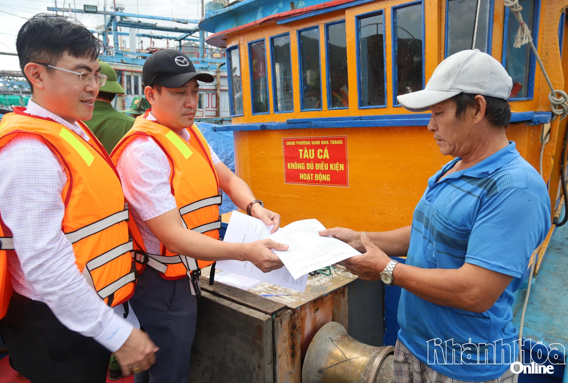 Đoàn công tác bàn giao biên bản làm việc cho một chủ tàu cá.