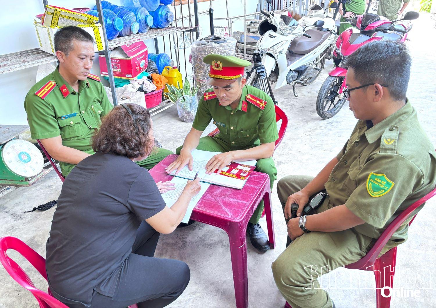 Công an xã hướng dẫn hộ dân ký cam kết thực hiện gia đình không ma túy.