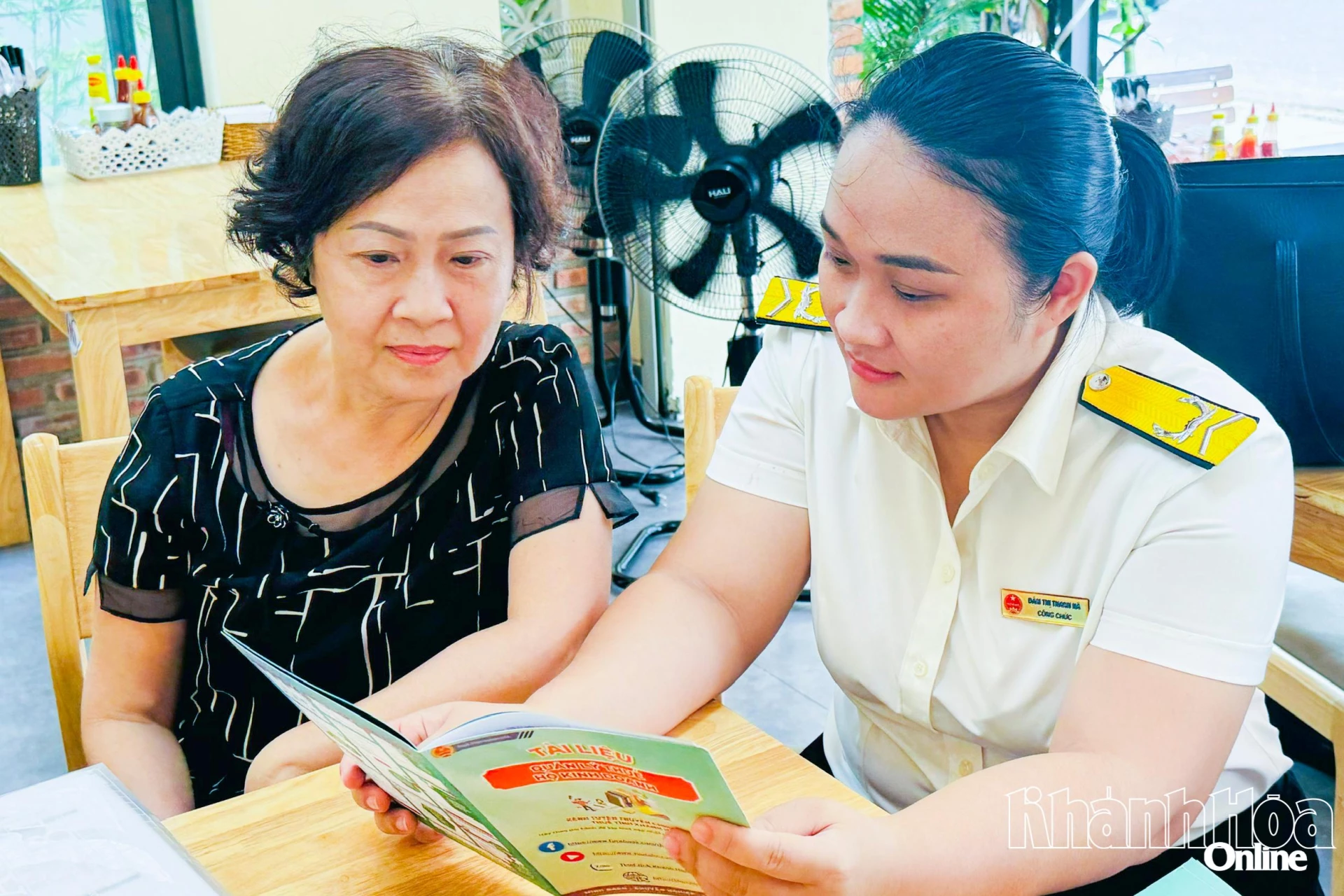 Cán bộ thuế giới thiệu tài liệu quy trình thực hiện việc chuyển đổi thuế khoán sang kê khai cho hộ kinh doanh tại phường Nha Trang.