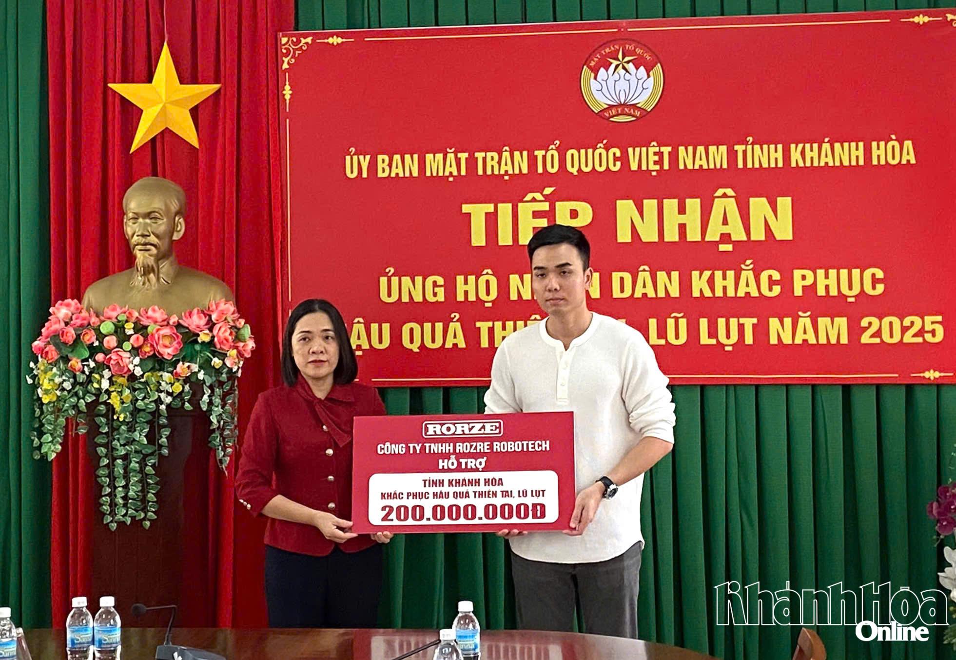 Đại diện Công ty TNHH ROZRE ROBOTECH trao bảng tượng trưng ủng hộ kinh phí cho người dân khắc phục thiệt hại do mưa