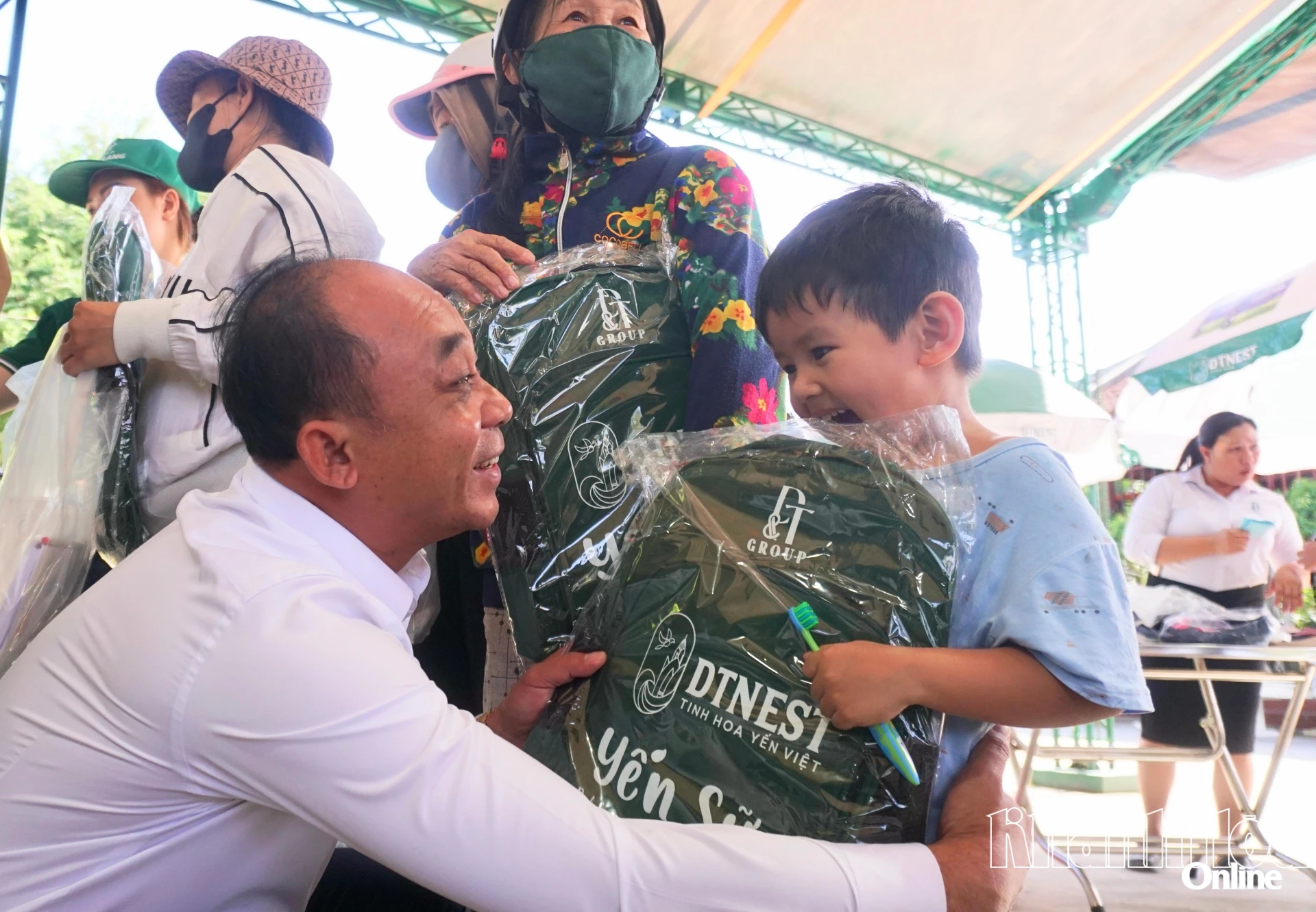 Một em nhỏ vui mừng khi được tặng balo miễn phí tại gian hàng.