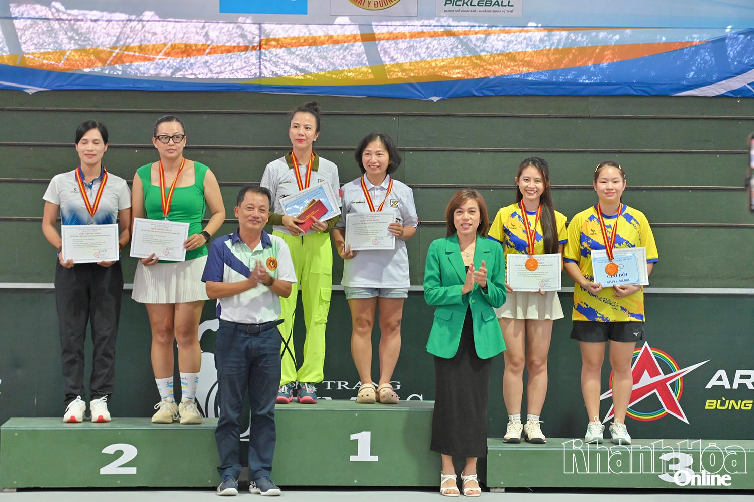 Ban tổ chức trao huy chương cho các đôi vận động viên nữ đạt thành tích cao tại giải.