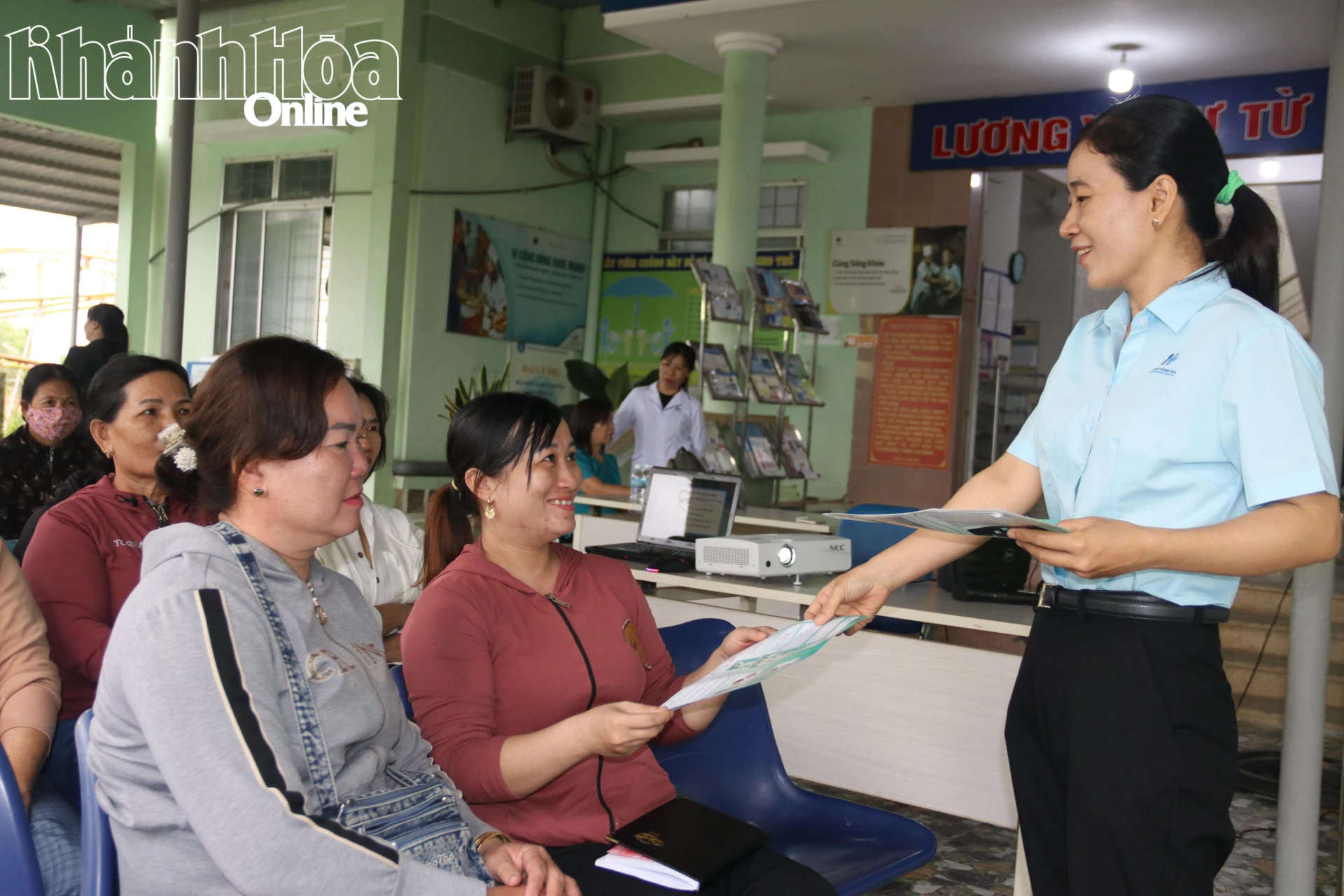 Cán bộ Trạm Y tế Ninh Quang phát tờ rơi tuyên truyền cho người dân.